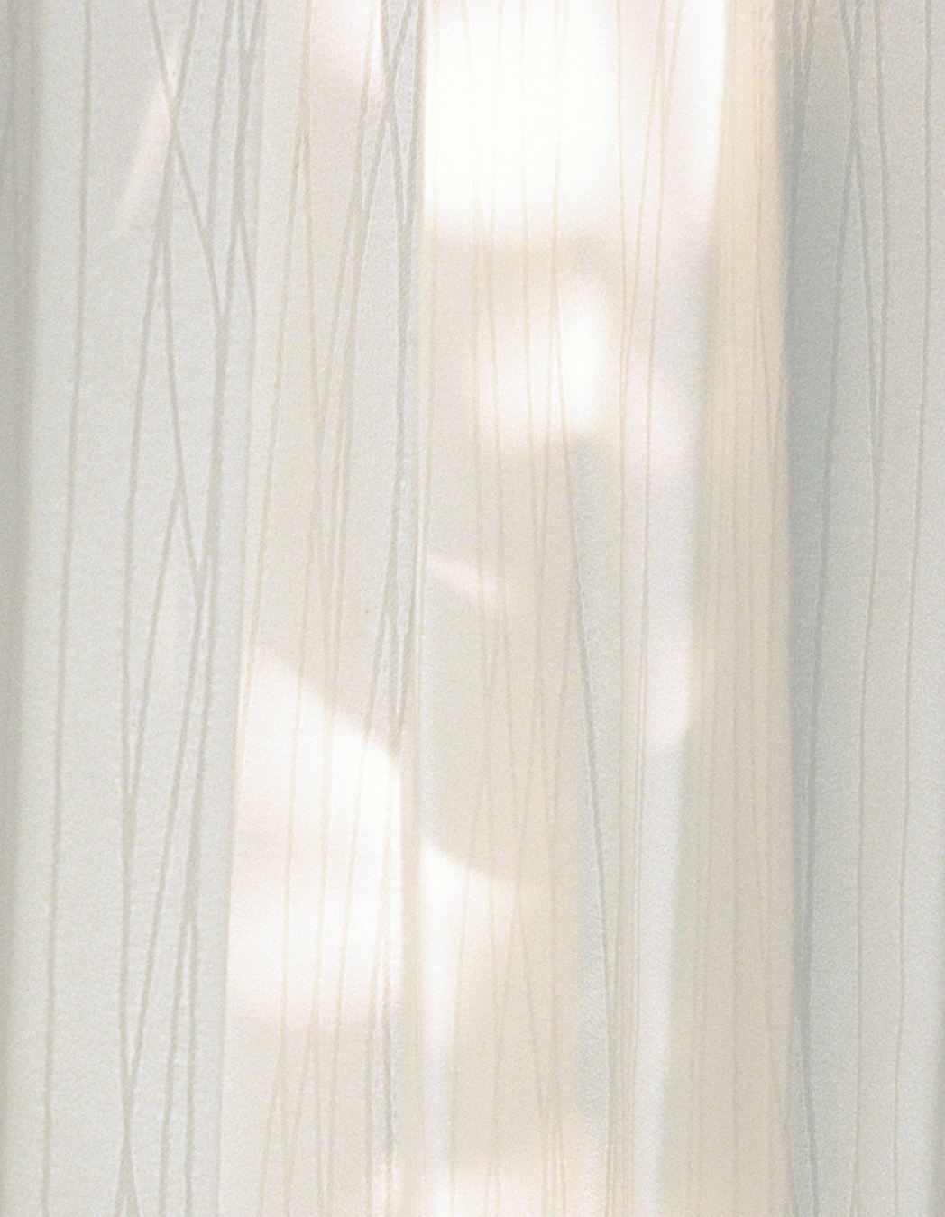 A sheer curtain with vertical lines, through which a blurred person can be seen, with a light-colored background.