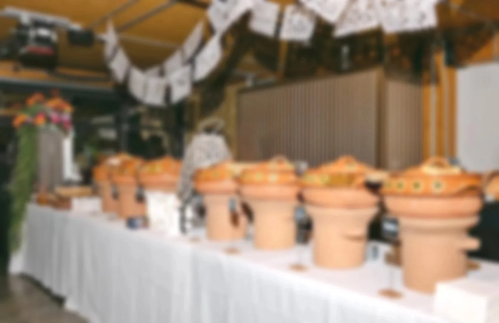A long table with various food dishes and a decorative string of paper or fabric hanging above it.