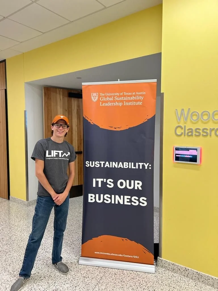 A young man wearing glasses, a gray T-shirt with
