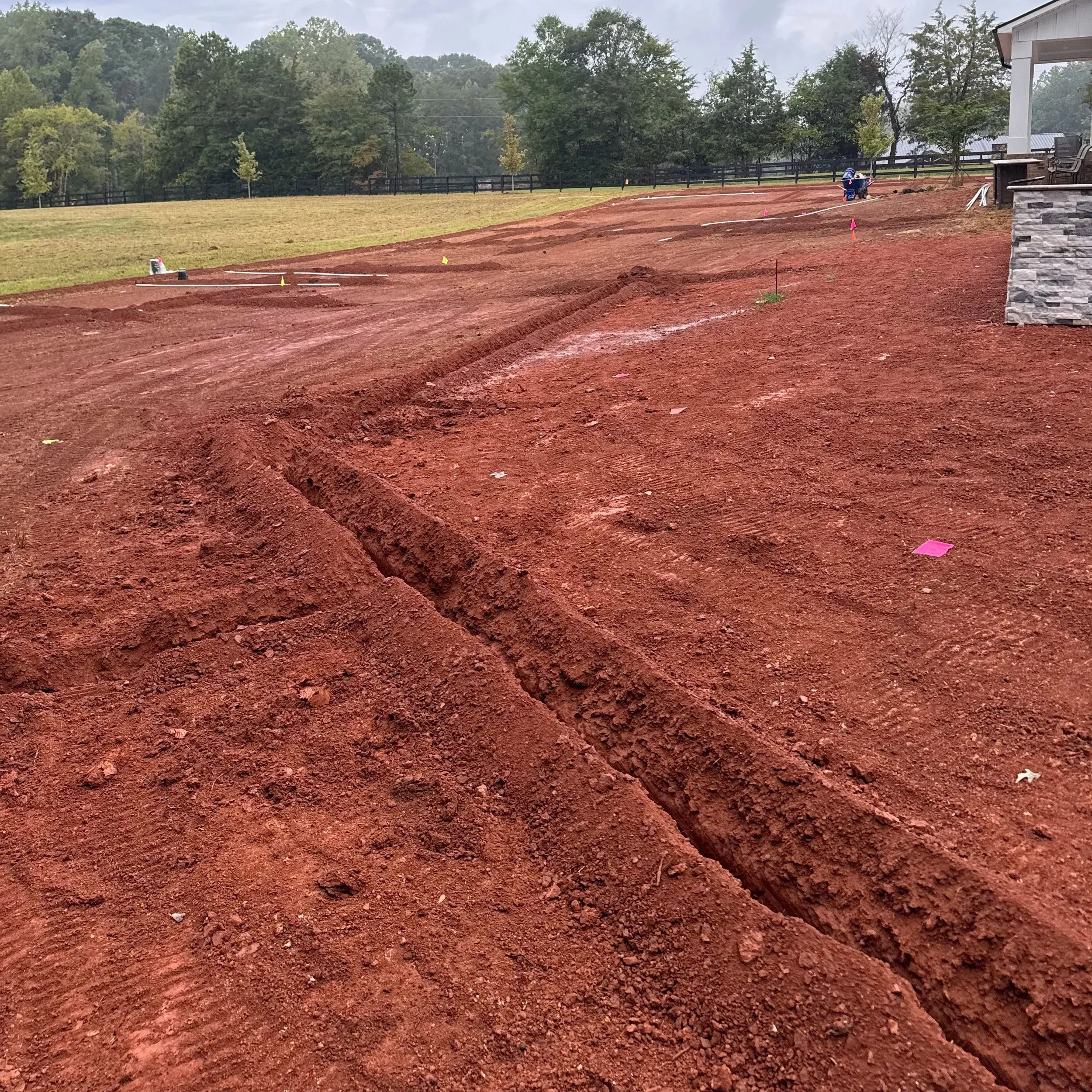 In-ground irrigation system being installed in red clay 