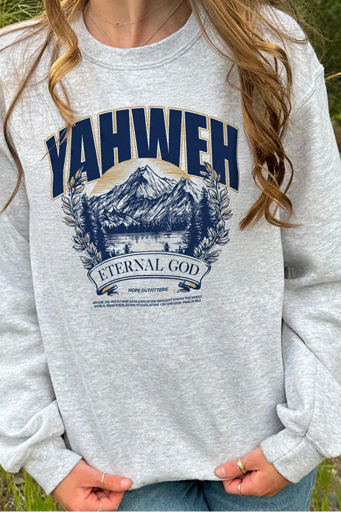 Gray sweatshirt featuring a mountain landscape, the words 'YAHWEH' in bold top text, and 'ETERNAL GOD' below the mountain scene, with a small Bible verse at the bottom.