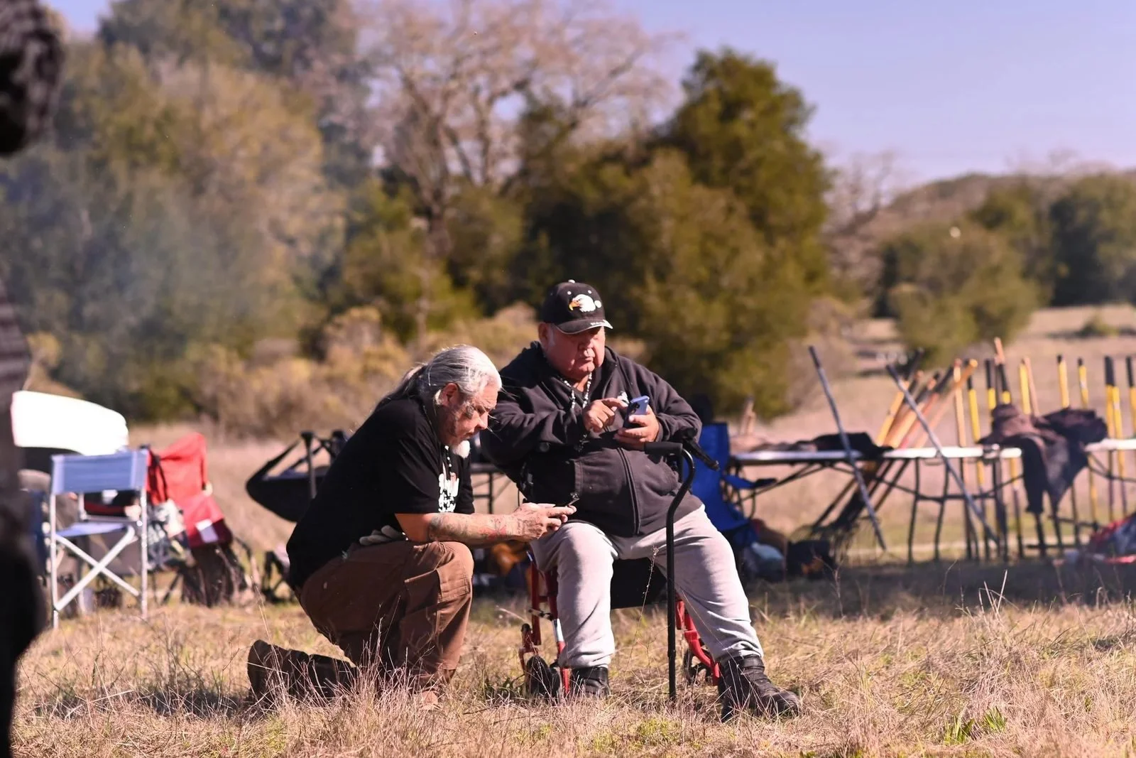 Two tribal elders confer in a grassy clearing during the cultural burn at 'Ootchamin 'Ooyakma