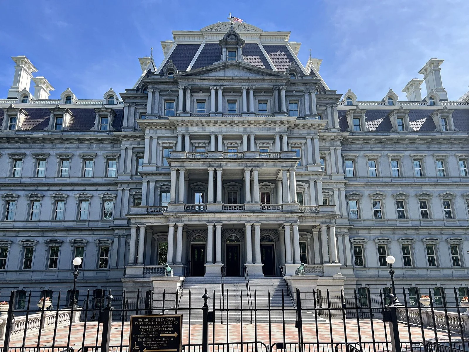 The ornate gray Second Empire facade of the Eisenhower Executive Office Building with columns, dormers and a slate roof.