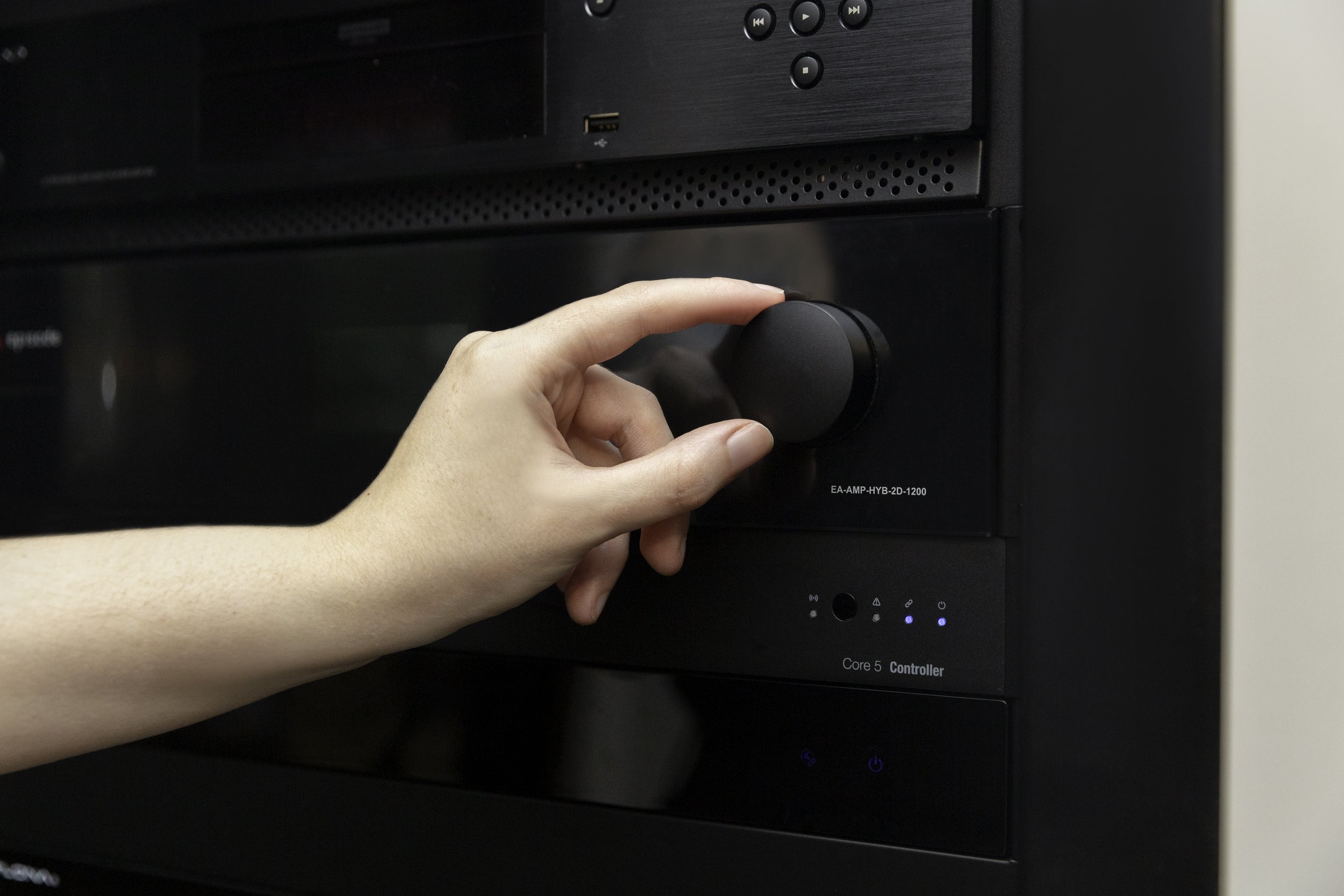 A person's hand adjusting a black computer tower's control knob labeled 'Core 5 Controller'.
