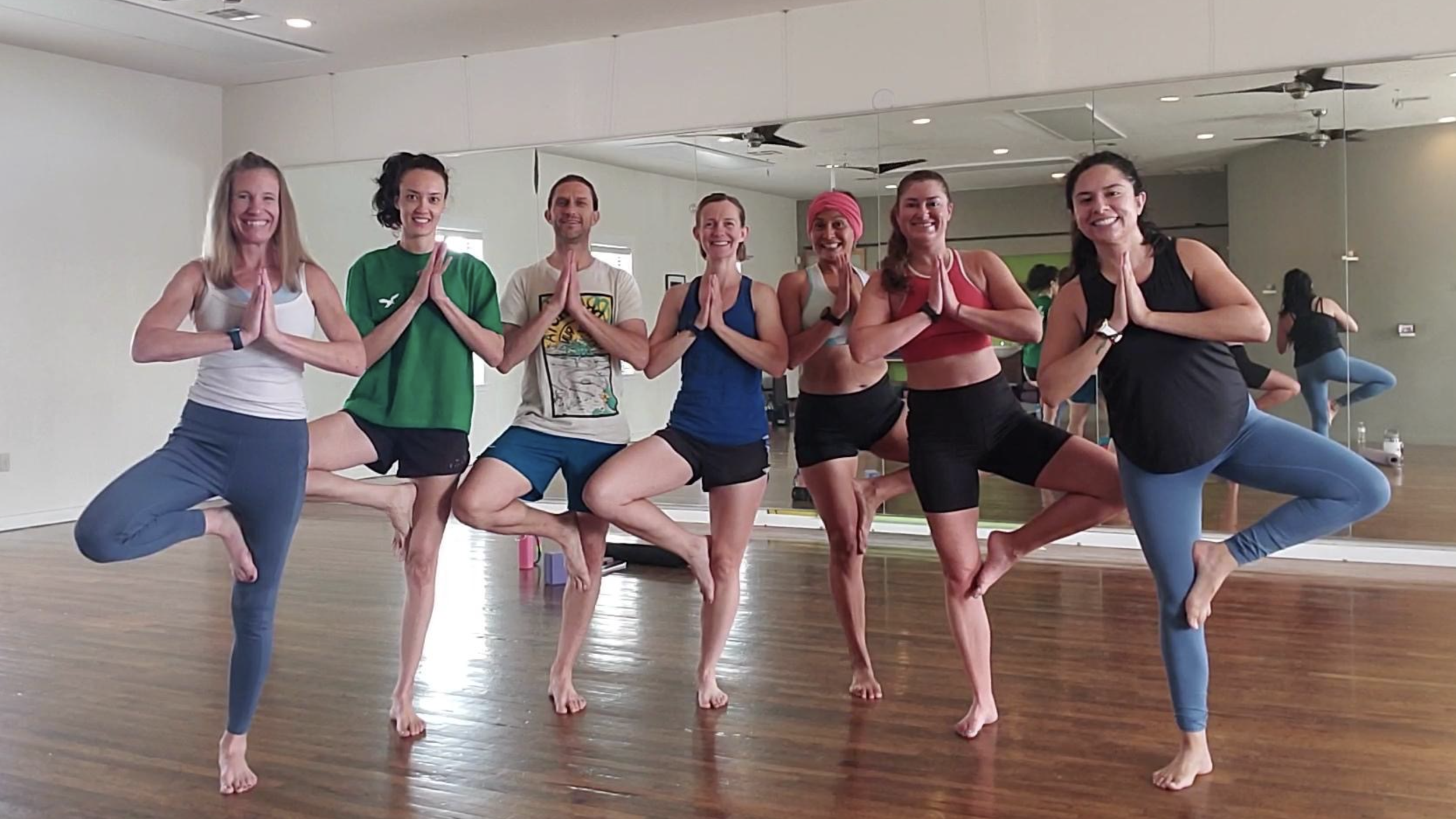 Group of people doing yoga together in a studio.