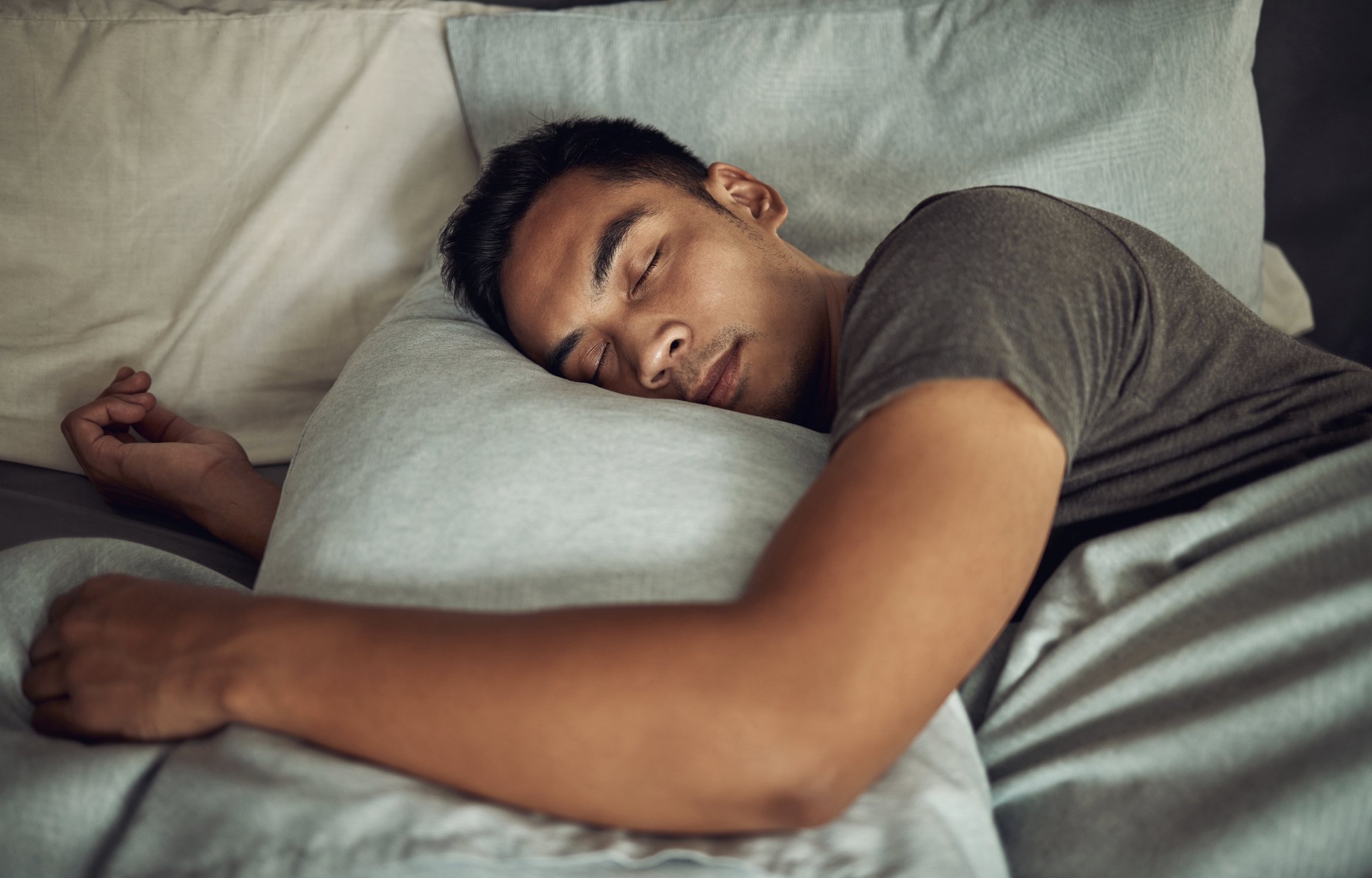 Man resting in bed, representing balanced sleep and recovery.