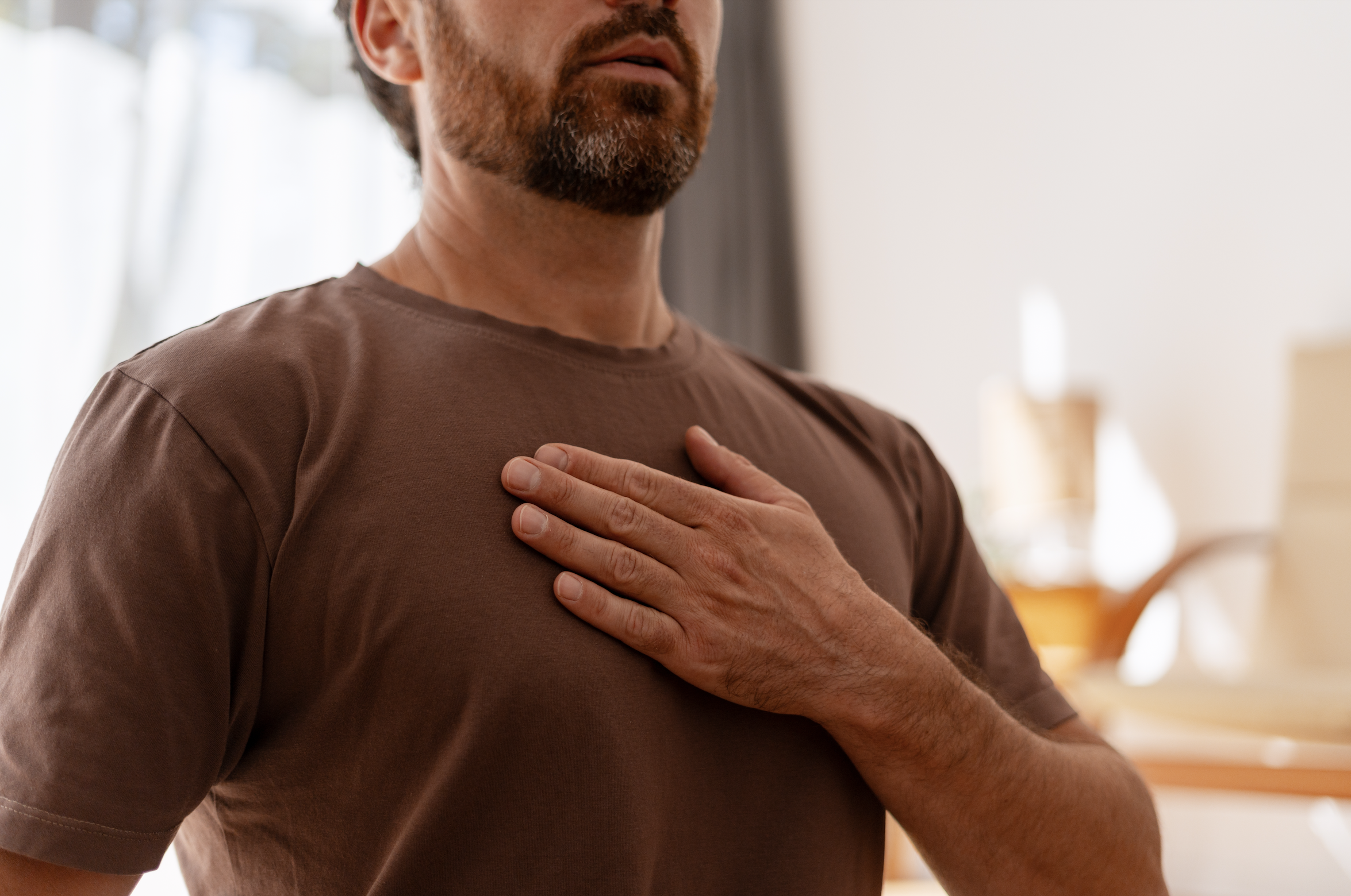 Man holding his chest and taking a moment to manage stress.