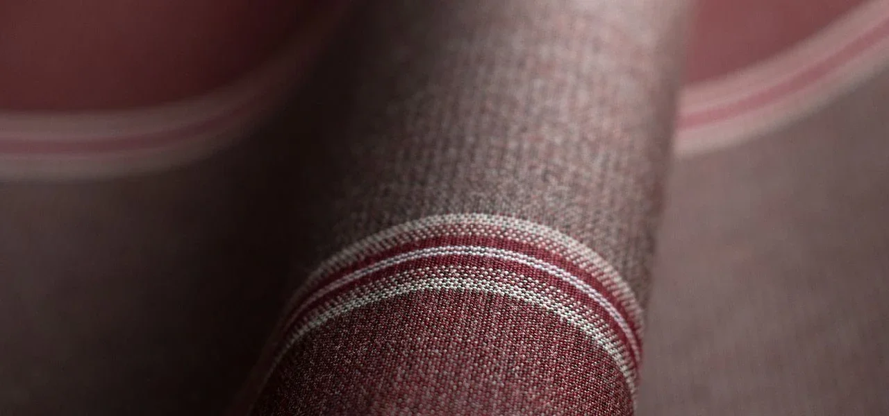 Close-up of a fabric with red and white stripes, possibly on a piece of clothing or upholstery.