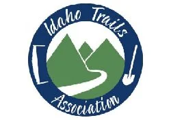 Logo of Idaho Trails Association featuring green mountains, a winding trail, and text 'Idaho Trails Association'
