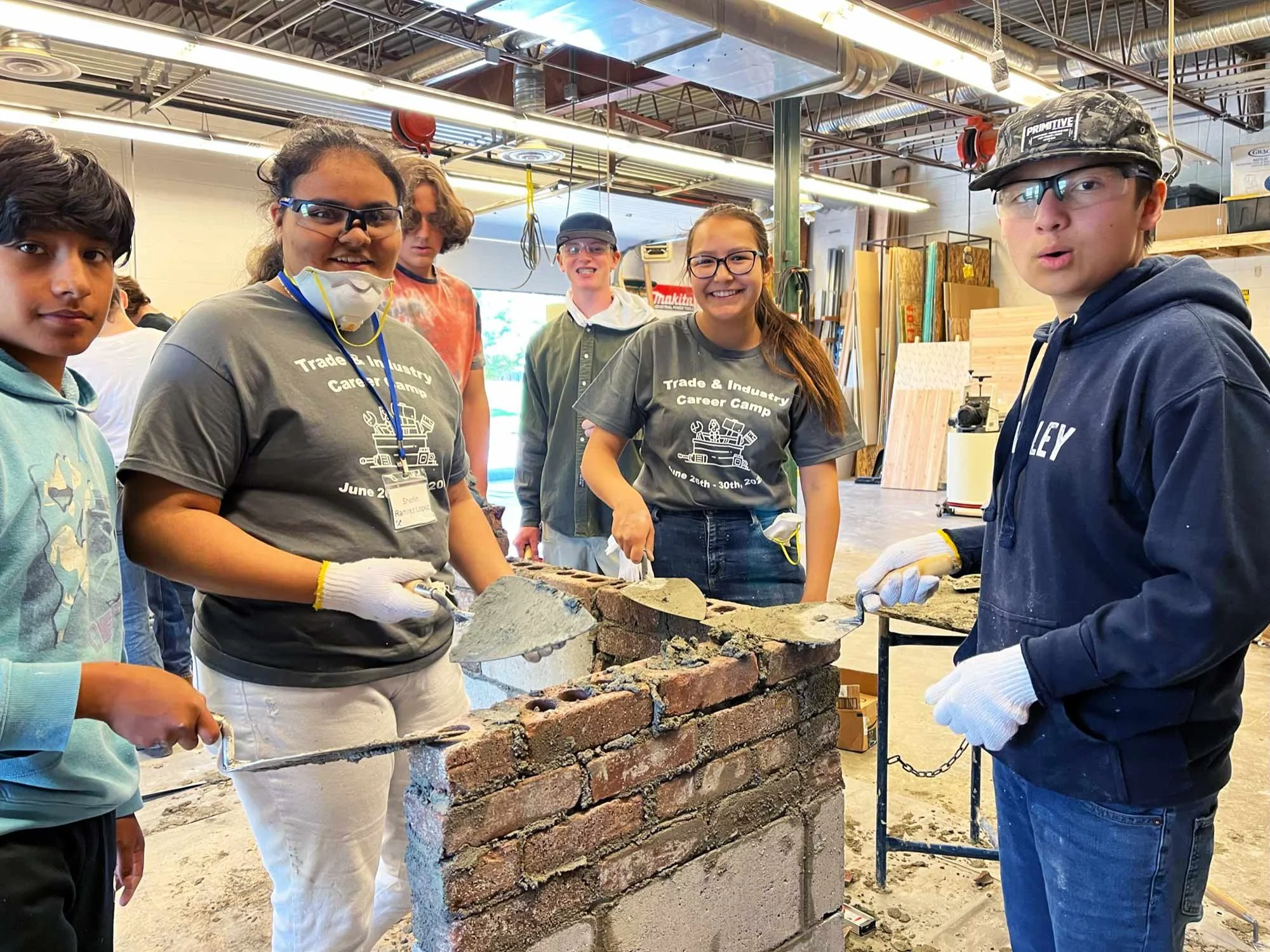 Group of students working together on a bricklaying project in a workshop
