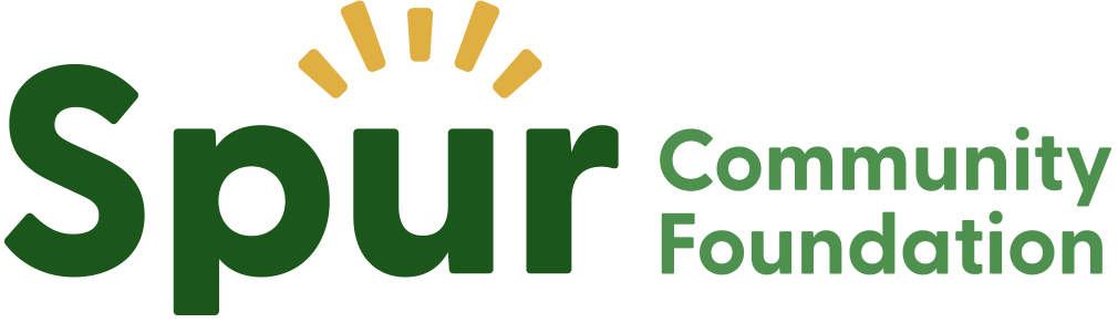 Logo for the Spur Community Foundation, featuring the word 'Spur' in large green letters with stylized yellow rays above the 'u', and the words 'Community Foundation' in smaller green letters to the right.