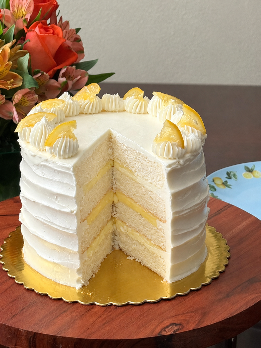 Lemon cake cut with flowers and lemon plates.png