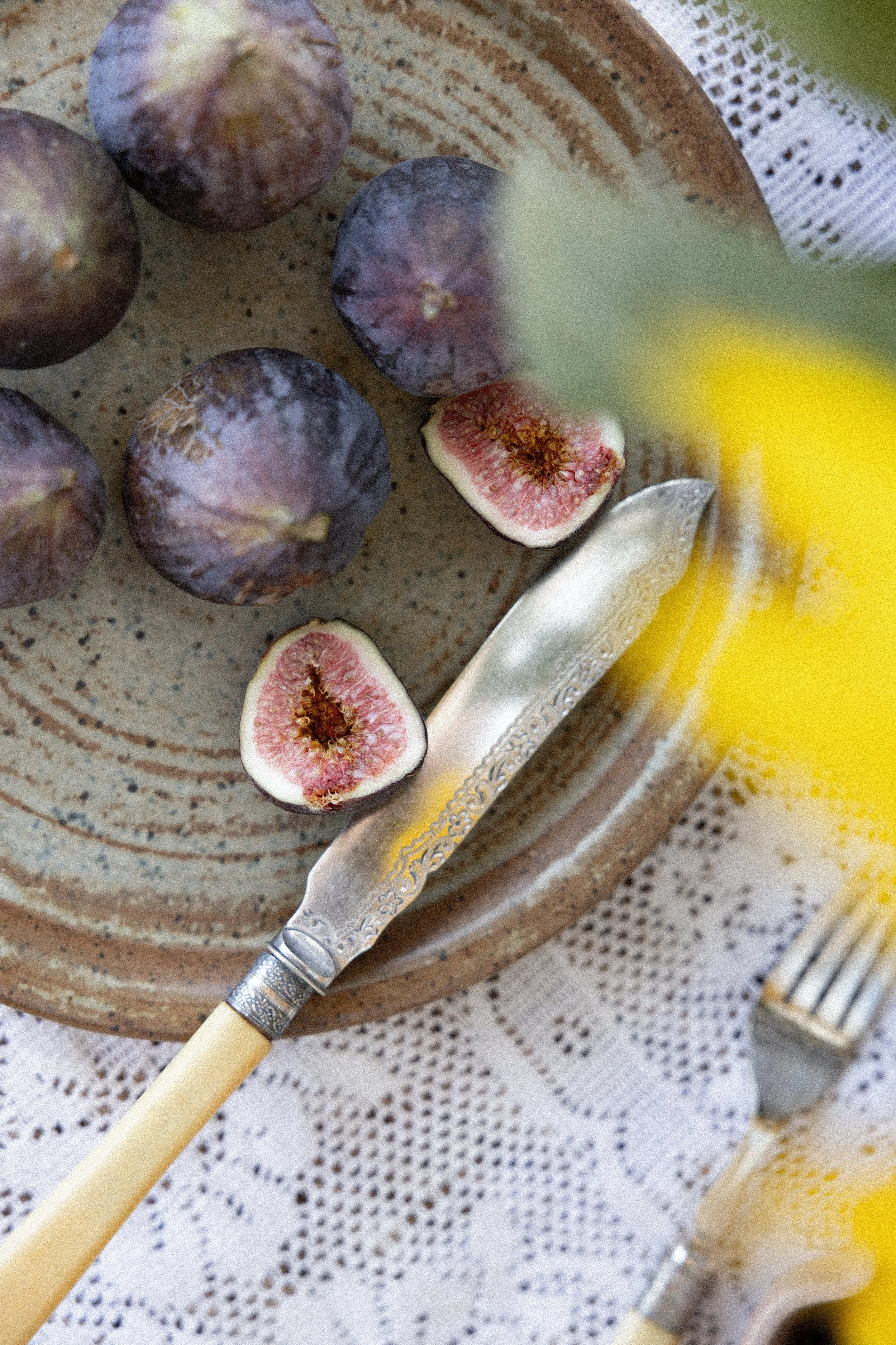 Figs and a fig half on a rustic plate with a vintage knife.