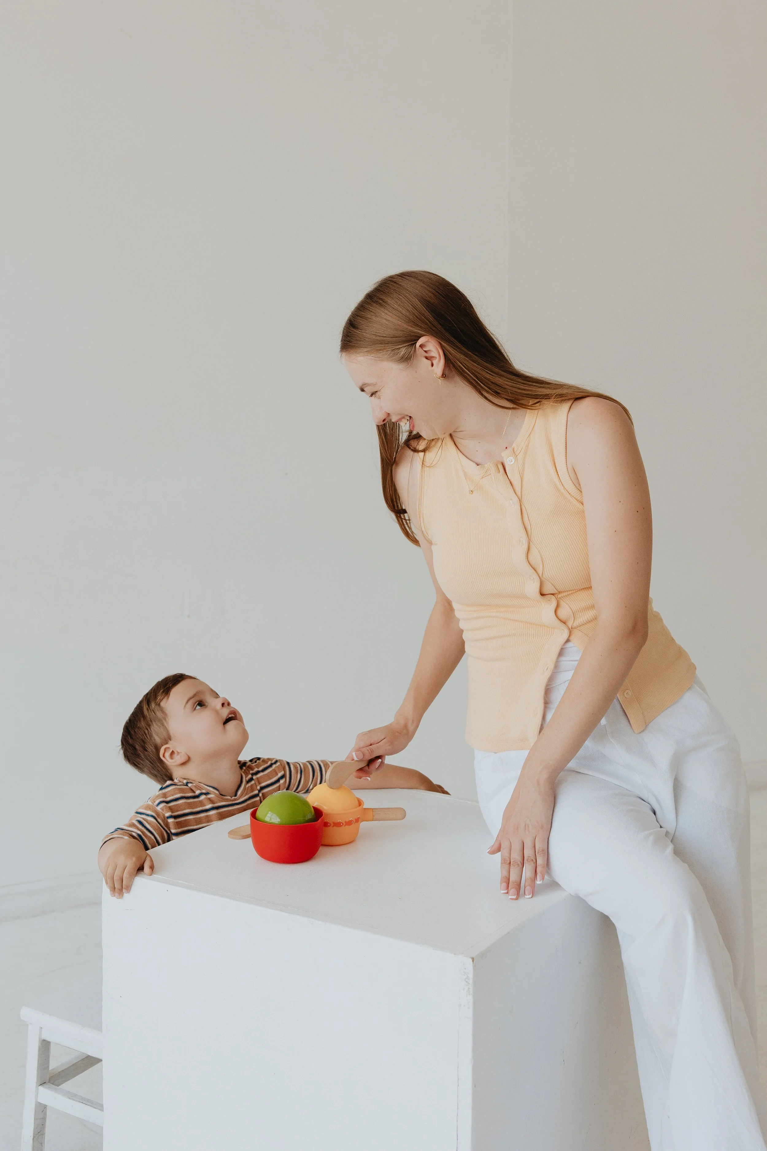 Toddler and adult playing with mixing bowls