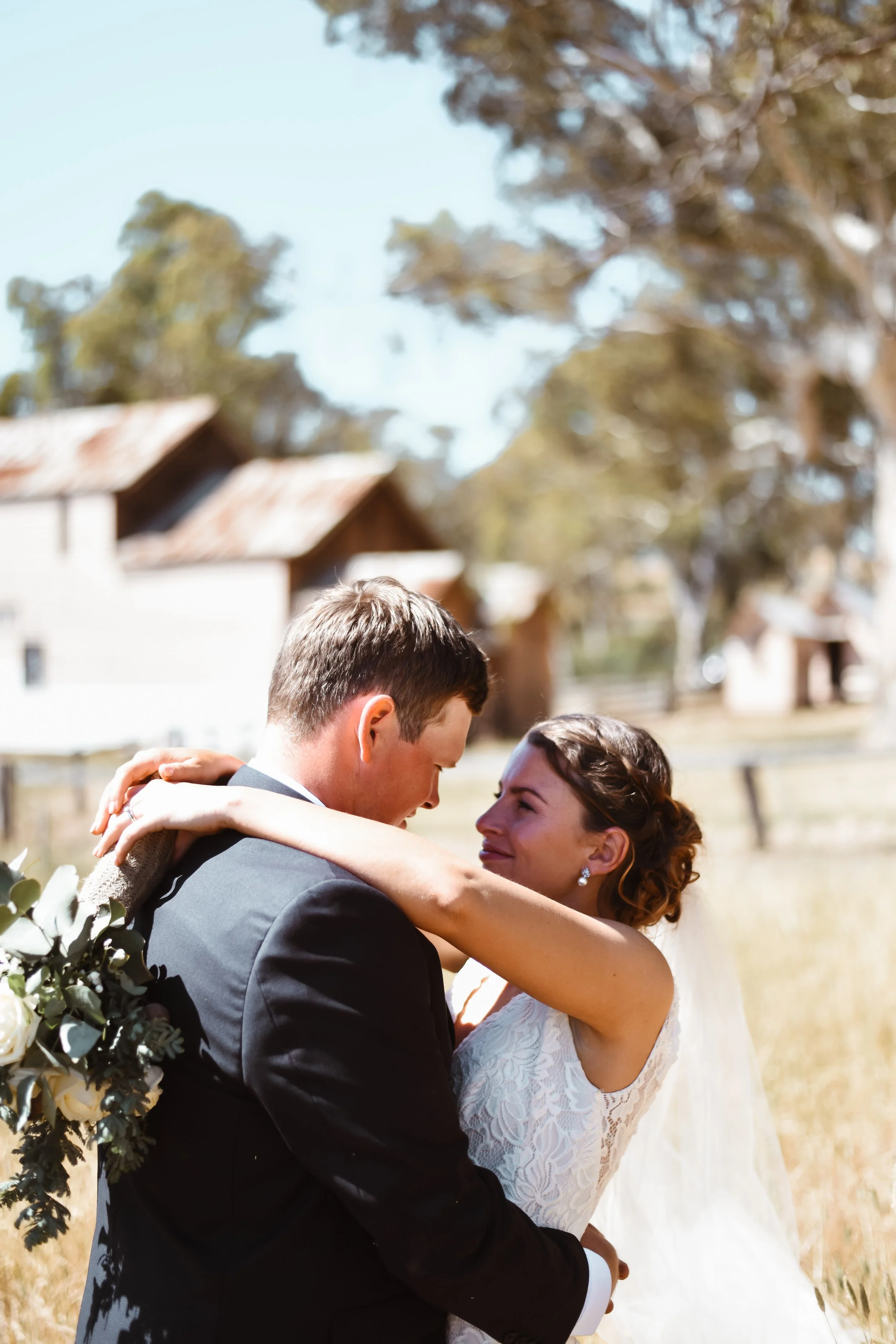 couple sharing a loving look while in a field of long grass