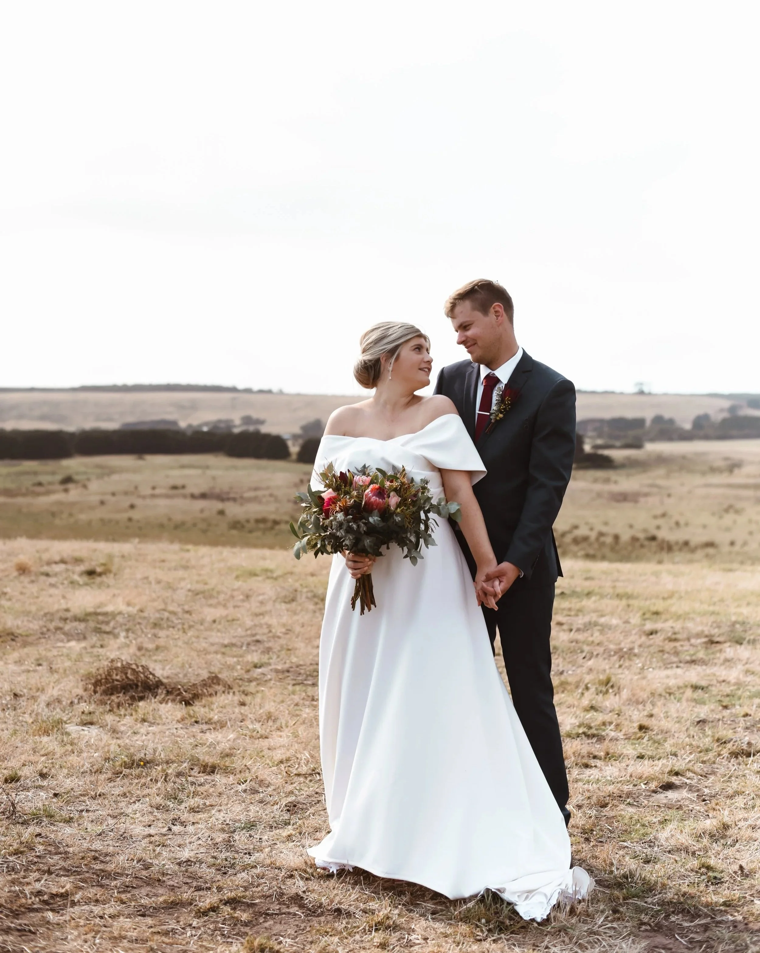 couple looking lovingly at each other while standing upon some hills
