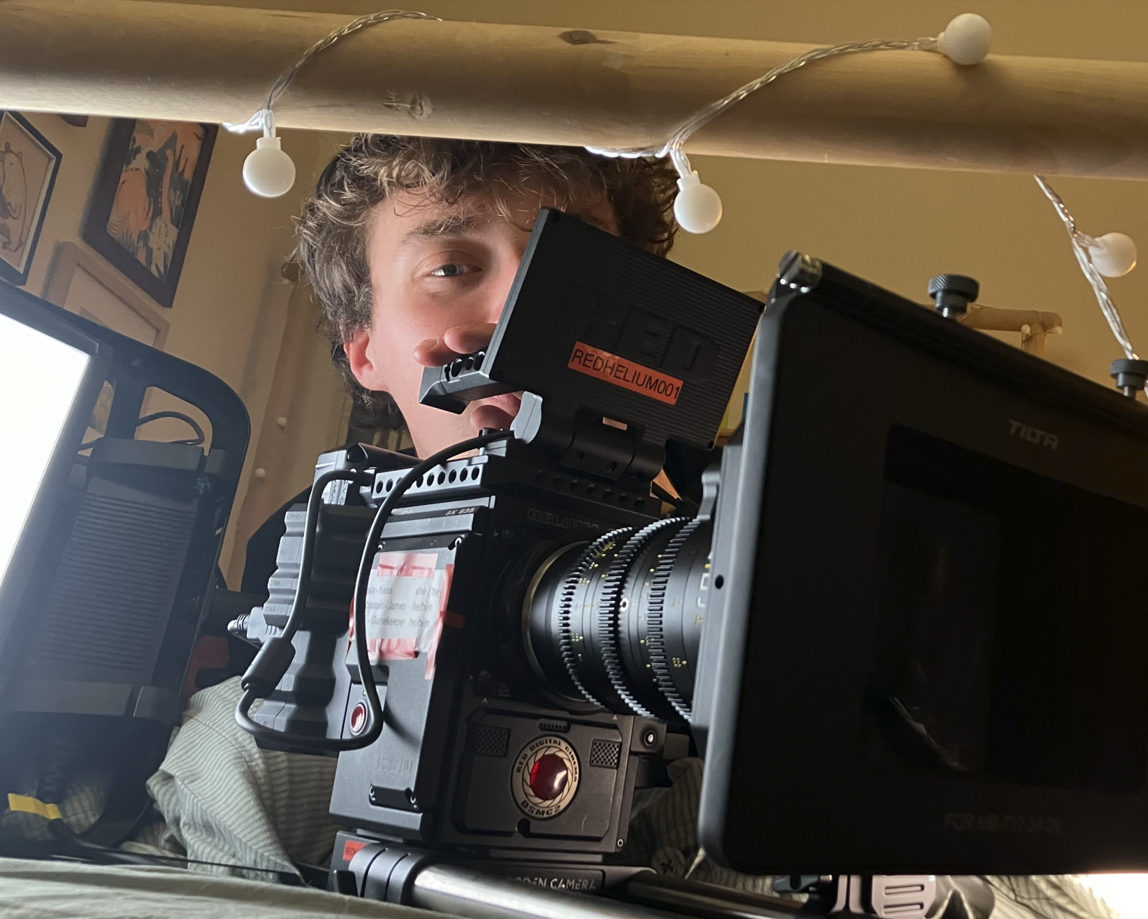 A person operating a professional film camera on set, with monitors and equipment around.