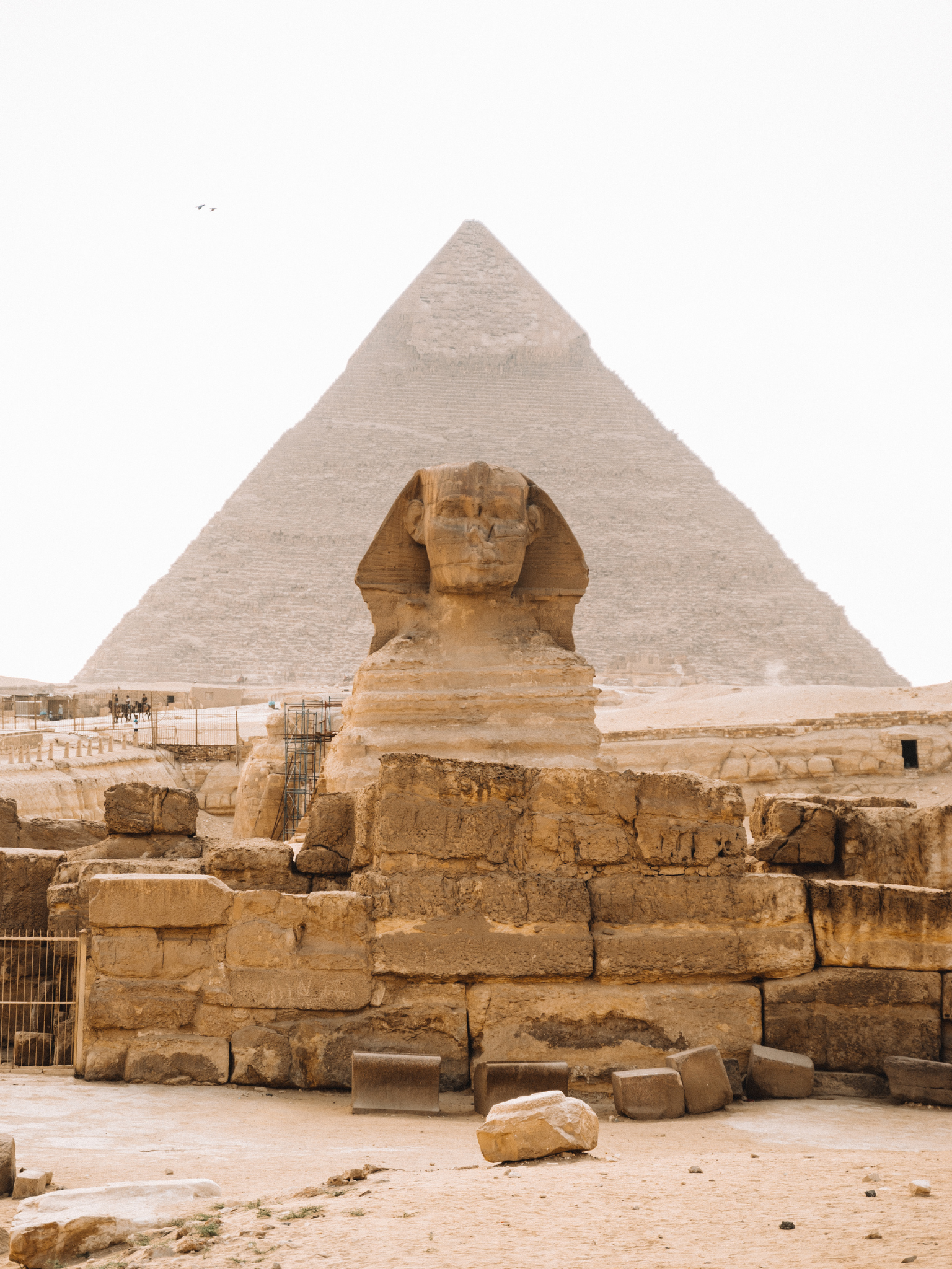 La Gran Esfinge de Giza frente a una pirámide en el desierto egipcio.