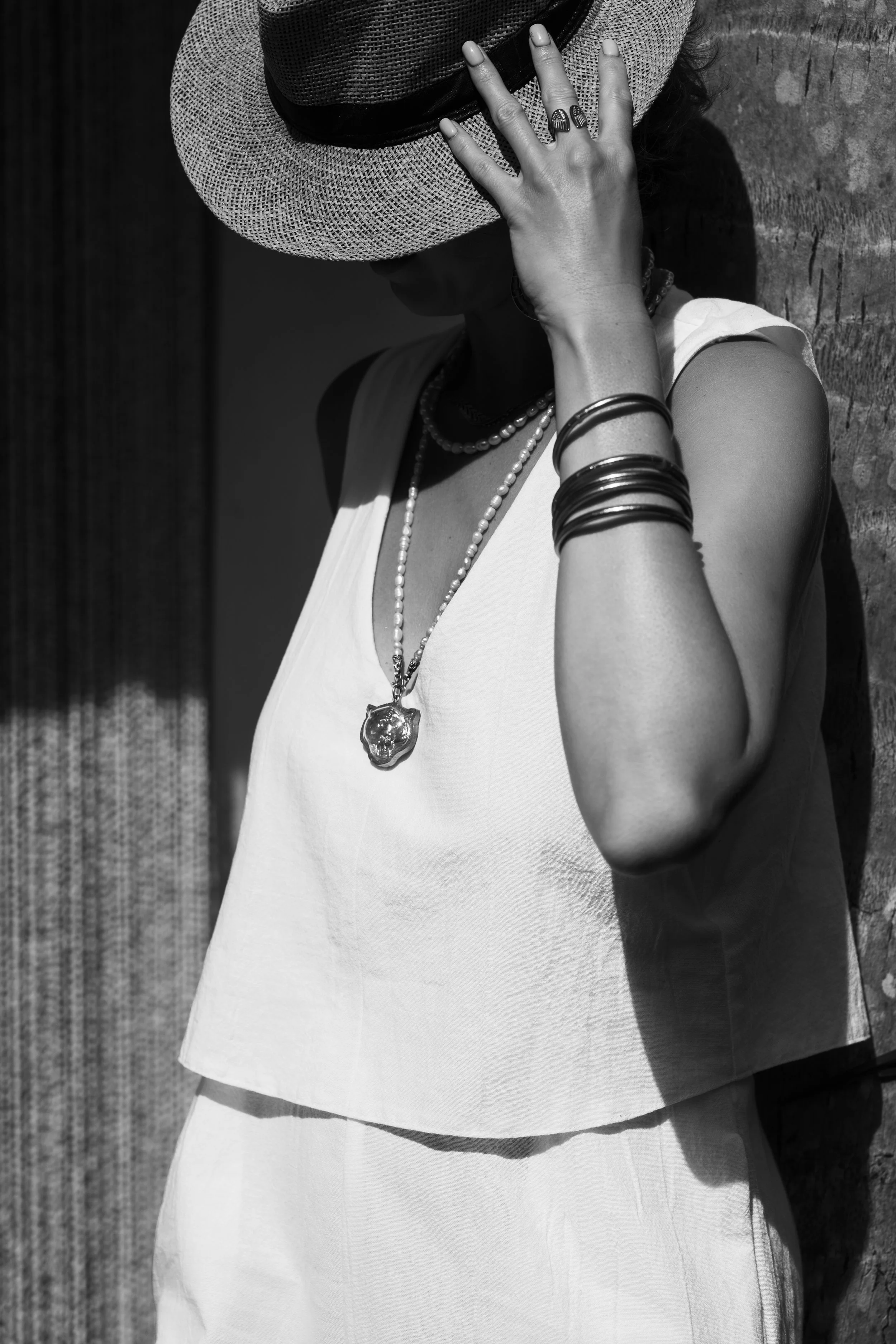 Woman standing in soft light, partially turned away, conveying presence, elegance, and quiet confidence.
