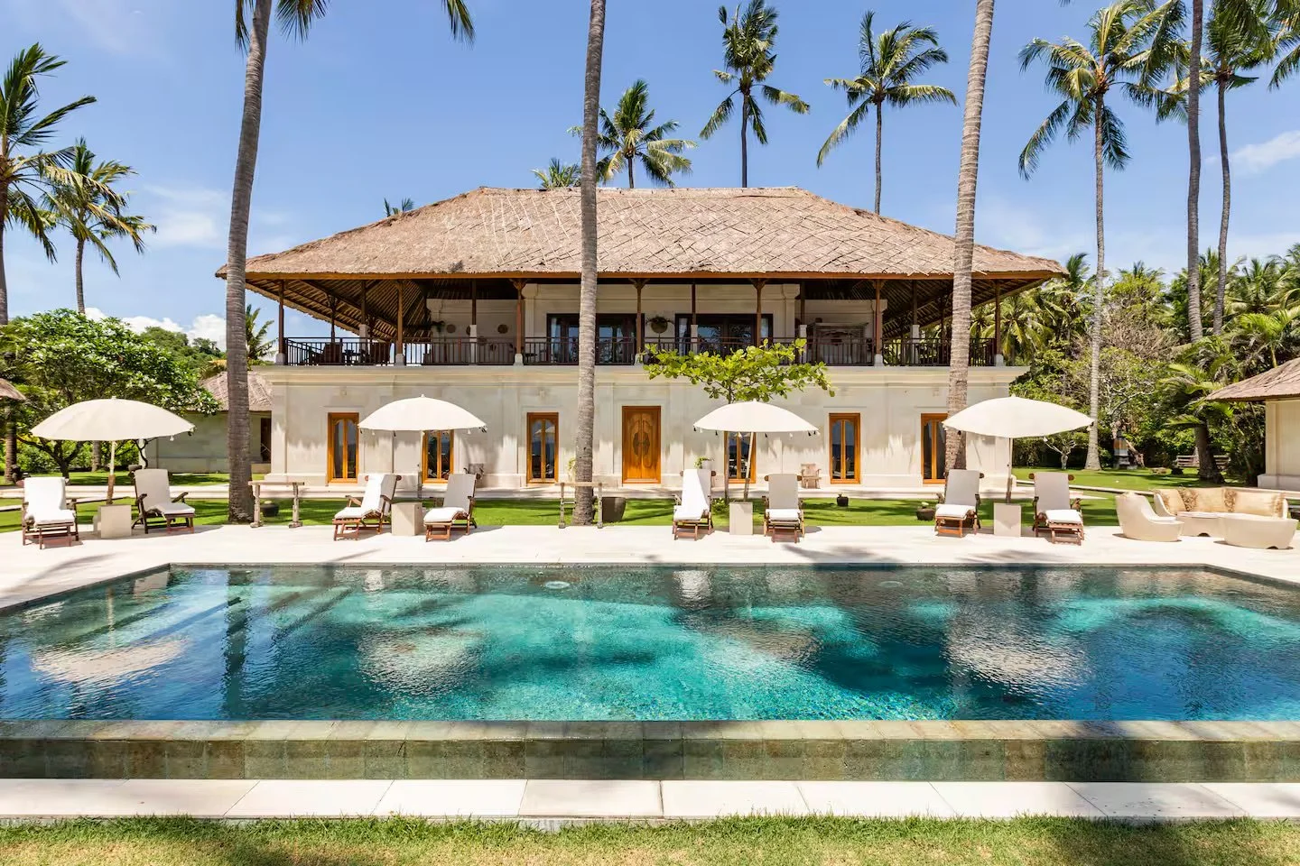 Private seafront villa in Bali with palm trees and pool, setting for a small, intentional retreat.