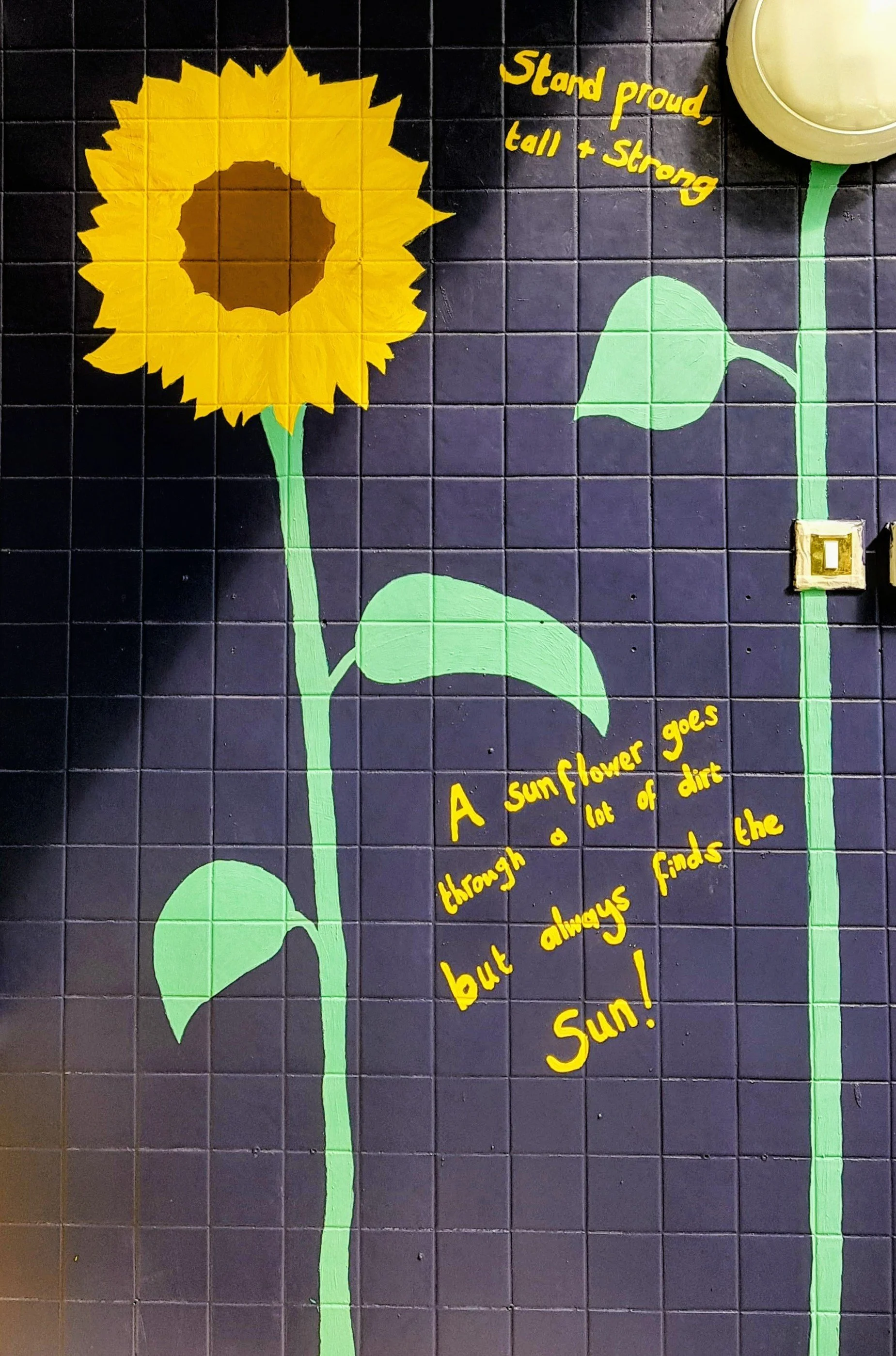 Wall mural of a sunflower with a quote that says, 'Stand proud, tall + strong,' and another quote that says, 'A sunflower goes through a lot of dirt but always finds the Sun!' - by Bronwyn Putman at Forgotten Loves