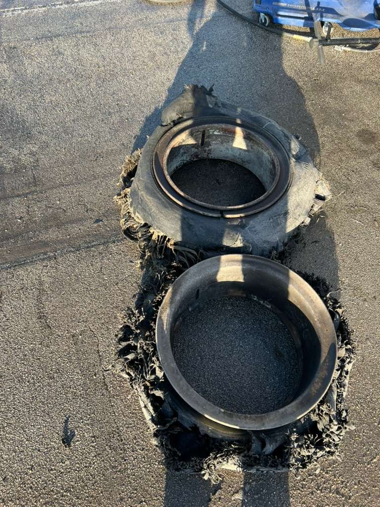 Two oval-shaped rubber drain seals embedded in an asphalt surface.