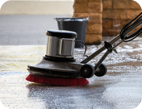 Commercial floor scrubber cleaning concrete flooring as part of facility maintenance services.