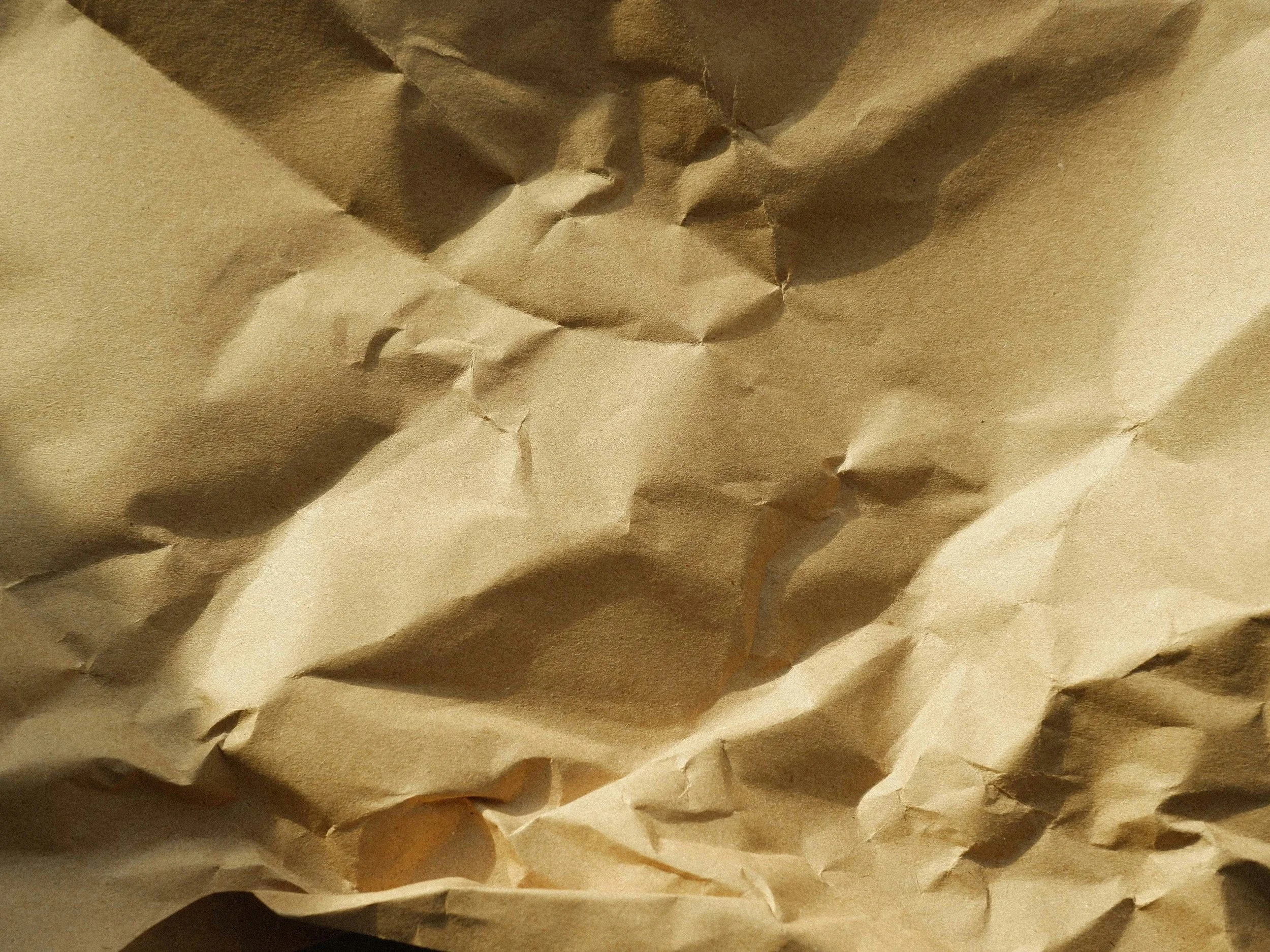 A crumpled sheet of brown paper with various folds and creases.
