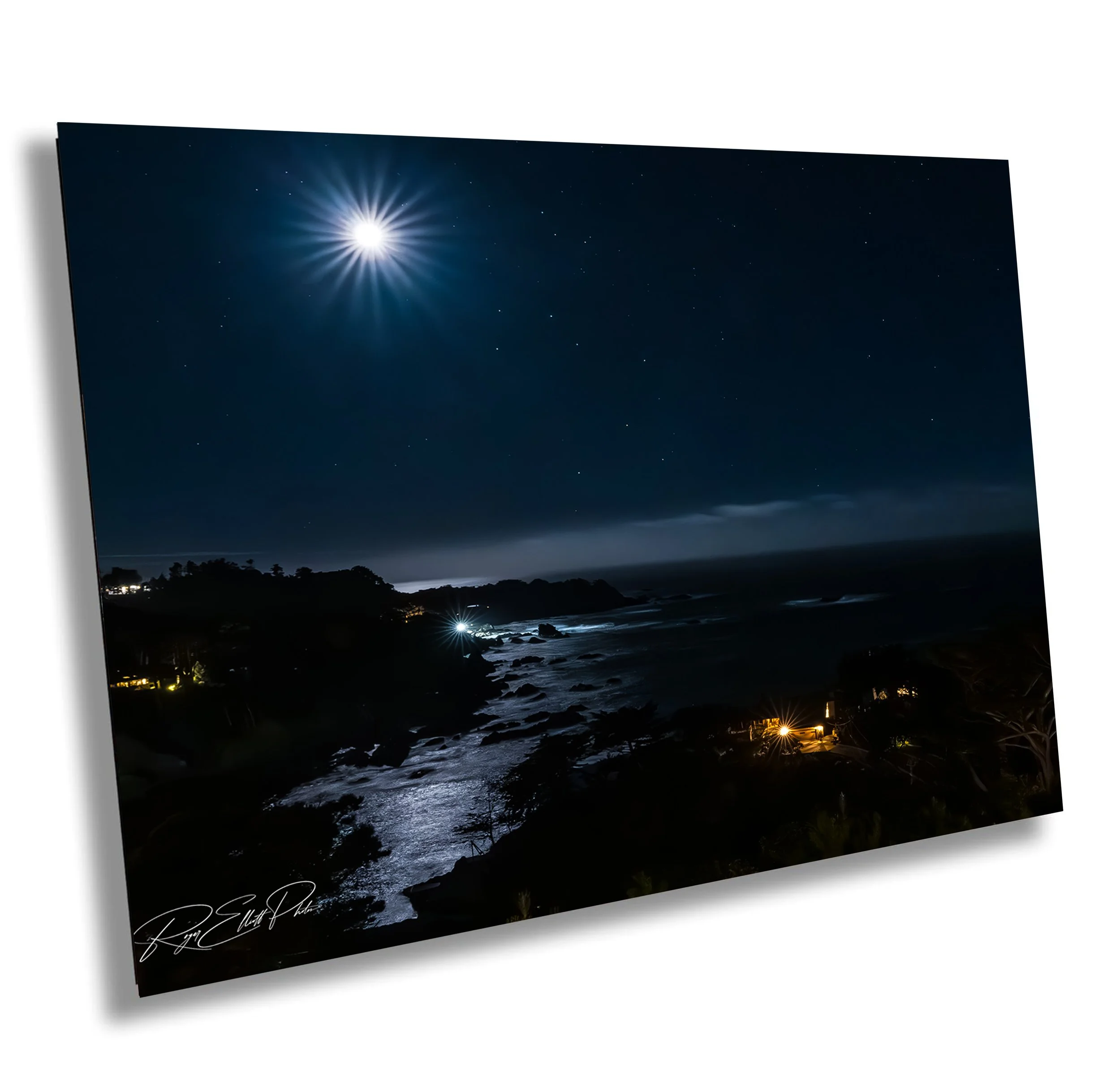 Nighttime coastal scene with bright moon and starry sky, illuminated water, and distant lights near the shoreline.