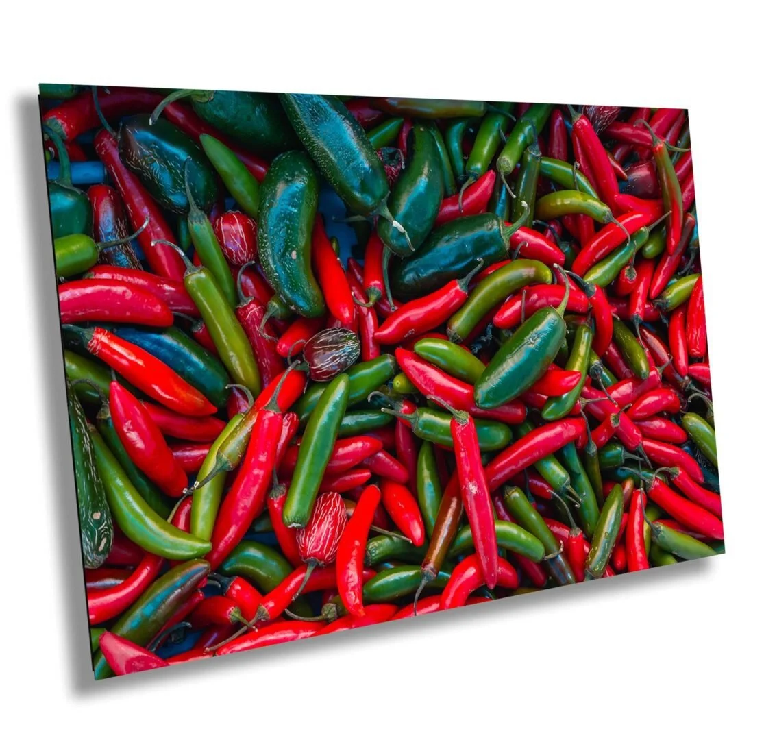 A variety of colorful chili peppers, including red, green, and dark green, piled together.