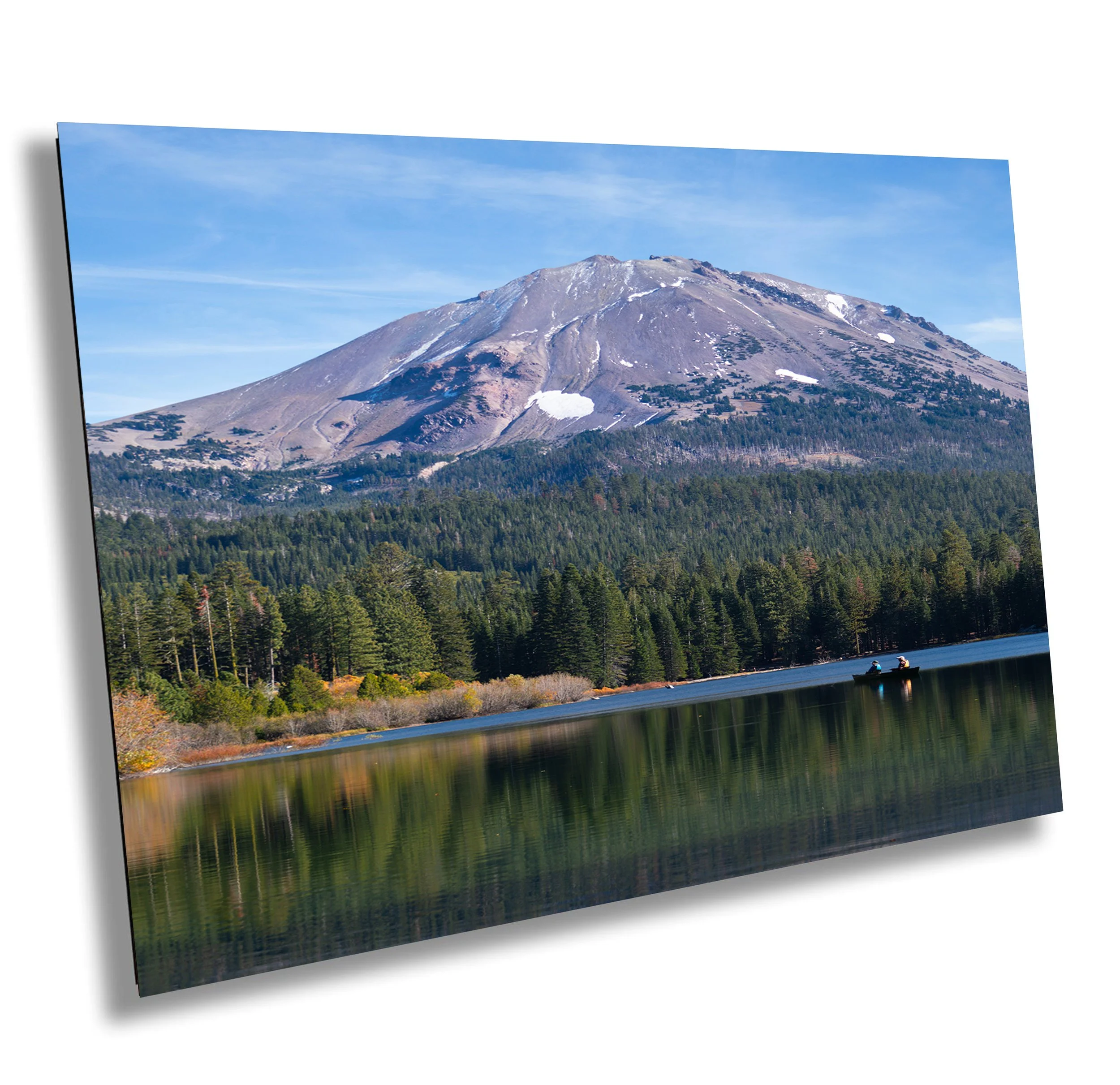 Snow-capped mountain over a forested landscape with a lake and boats