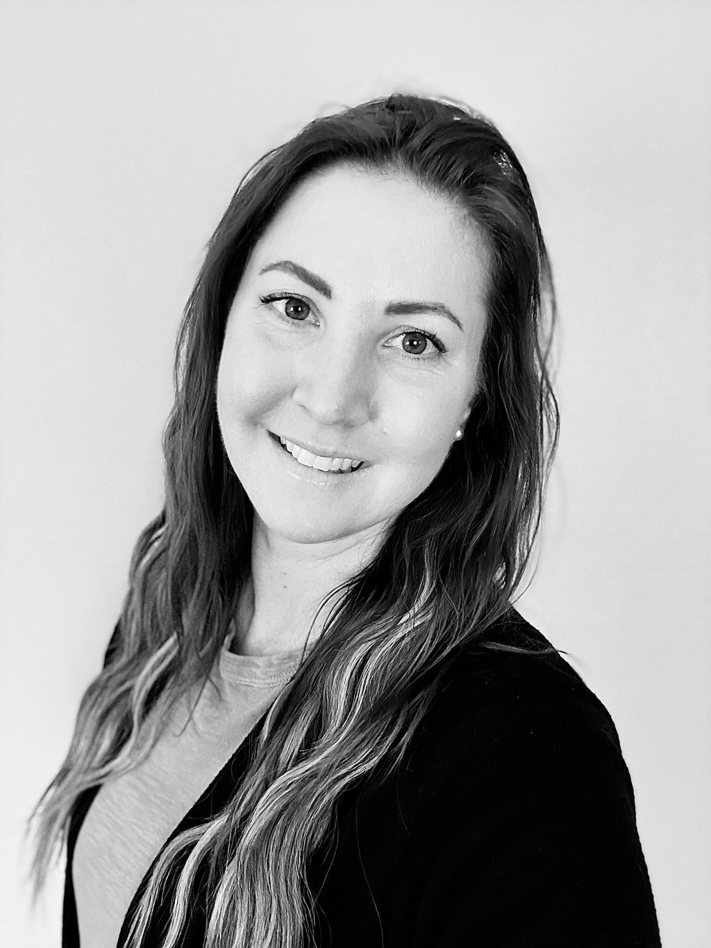 Black and white photo of a woman with wavy hair smiling at the camera
