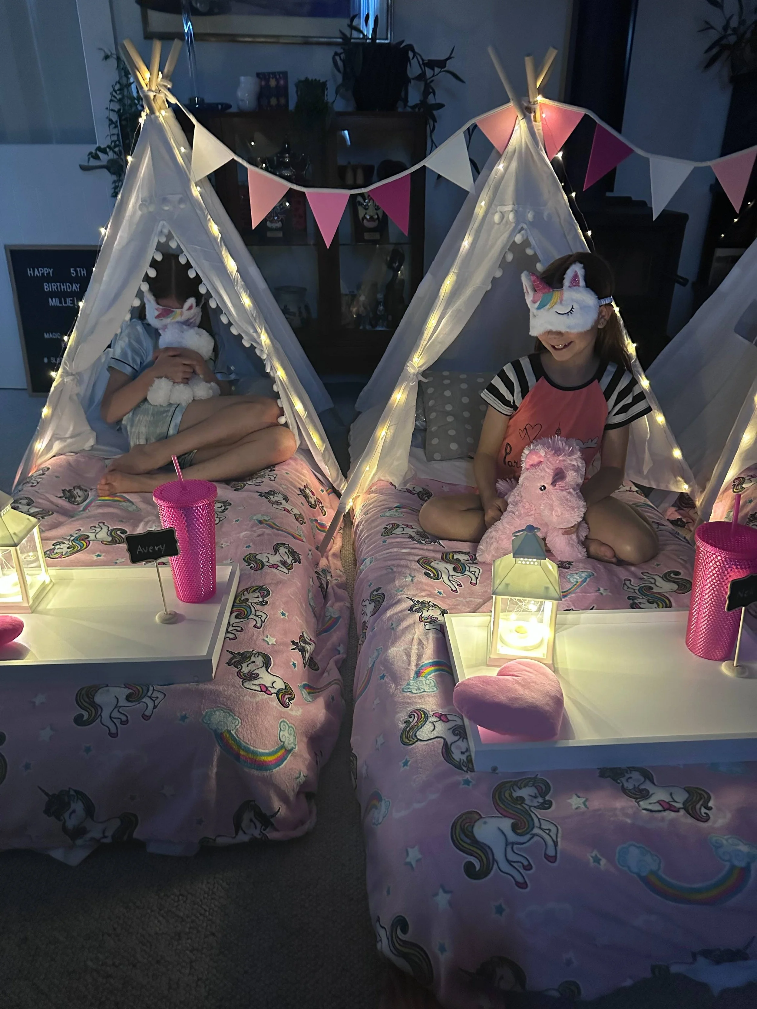 Pink unicorn-themed tents with fairy lights and more for Unicorn Kingdom slumber.