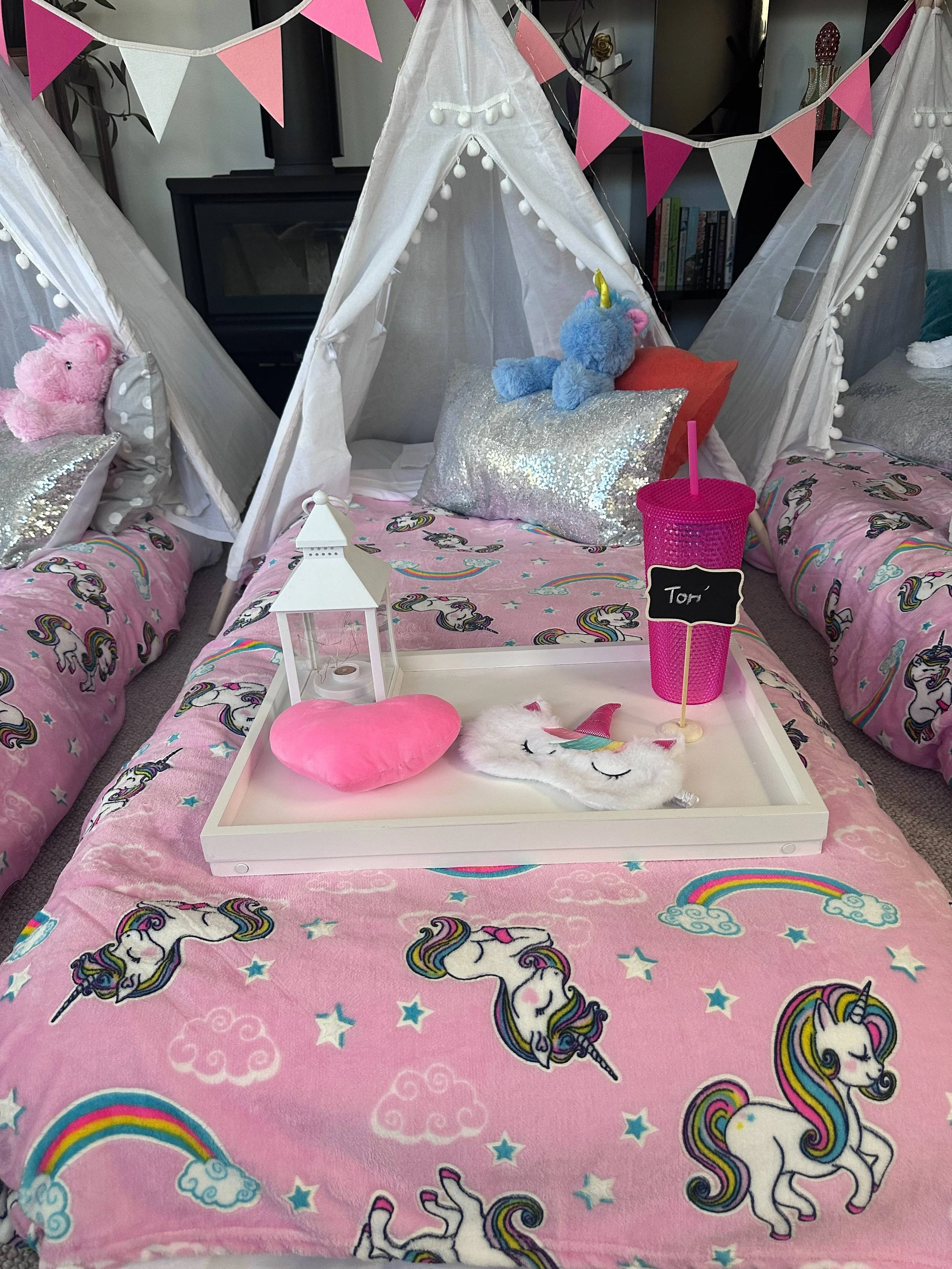 Kids' bed decorated with unicorn-themed bedding and accessories.