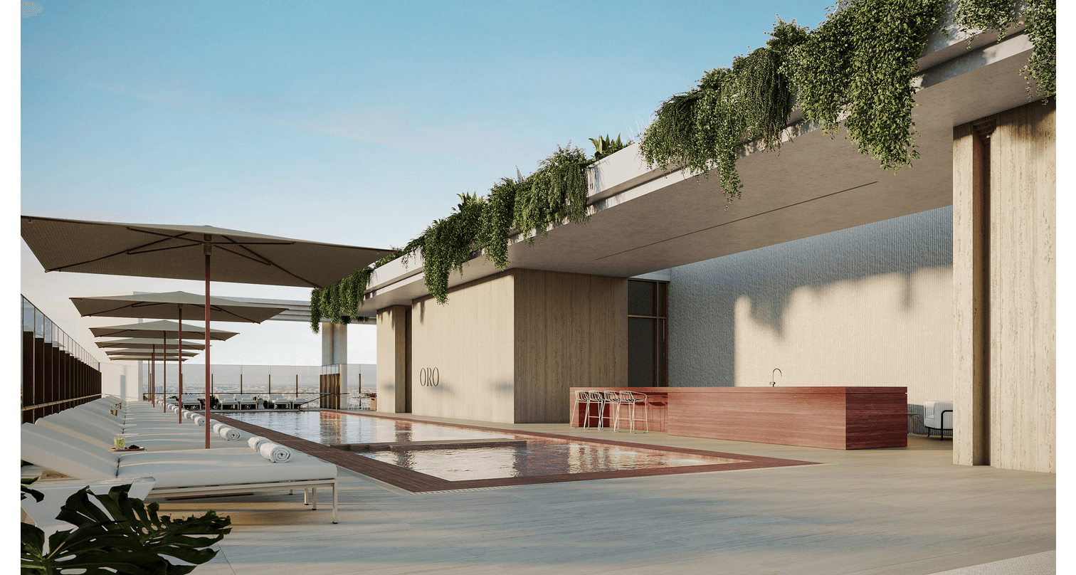 Luxury rooftop pool area with lounge chairs, umbrellas, and a bar with seating, overlooking ocean views on a clear day.