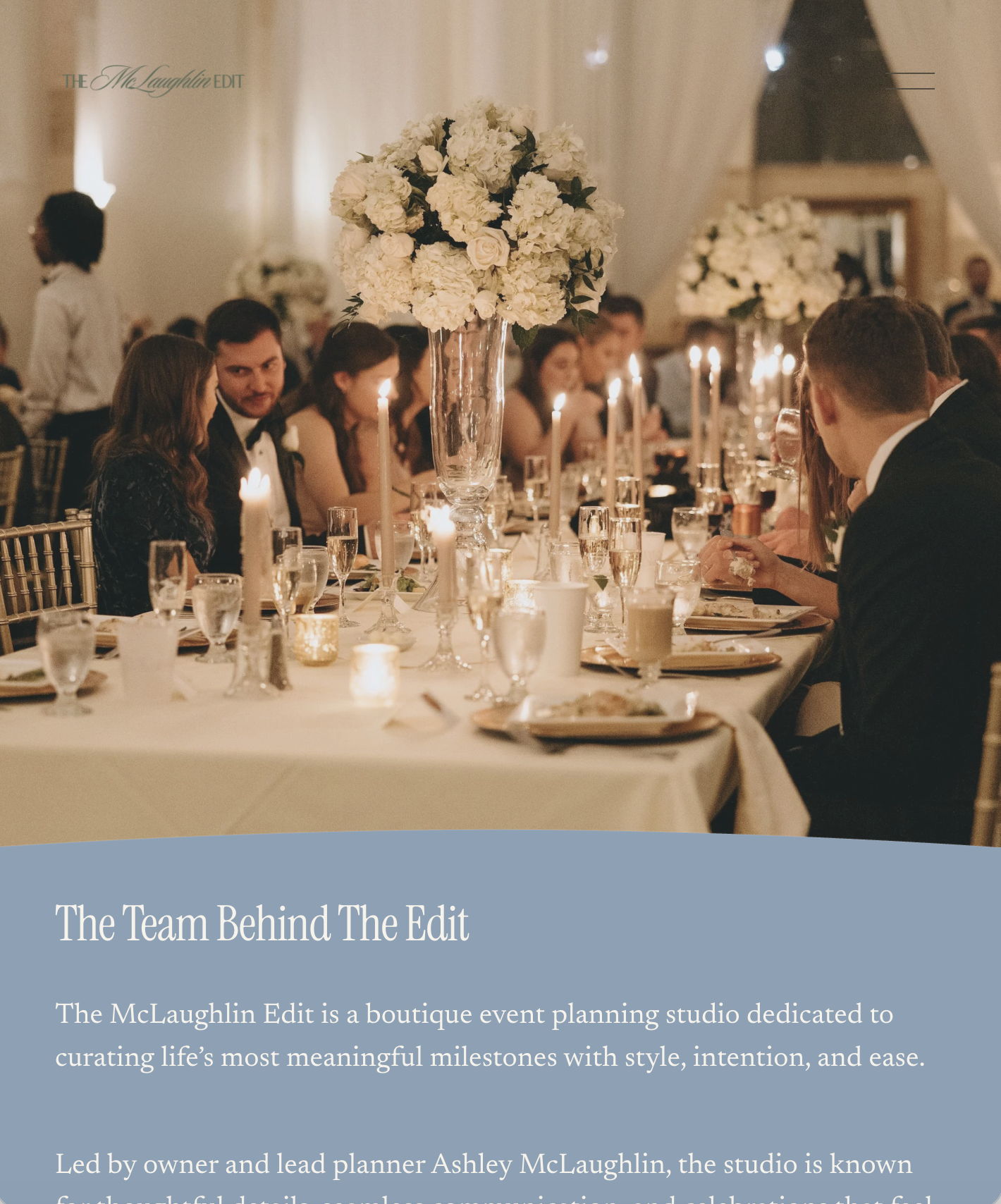 Elegant banquet table with floral arrangements and lit candles at an upscale event or wedding reception.