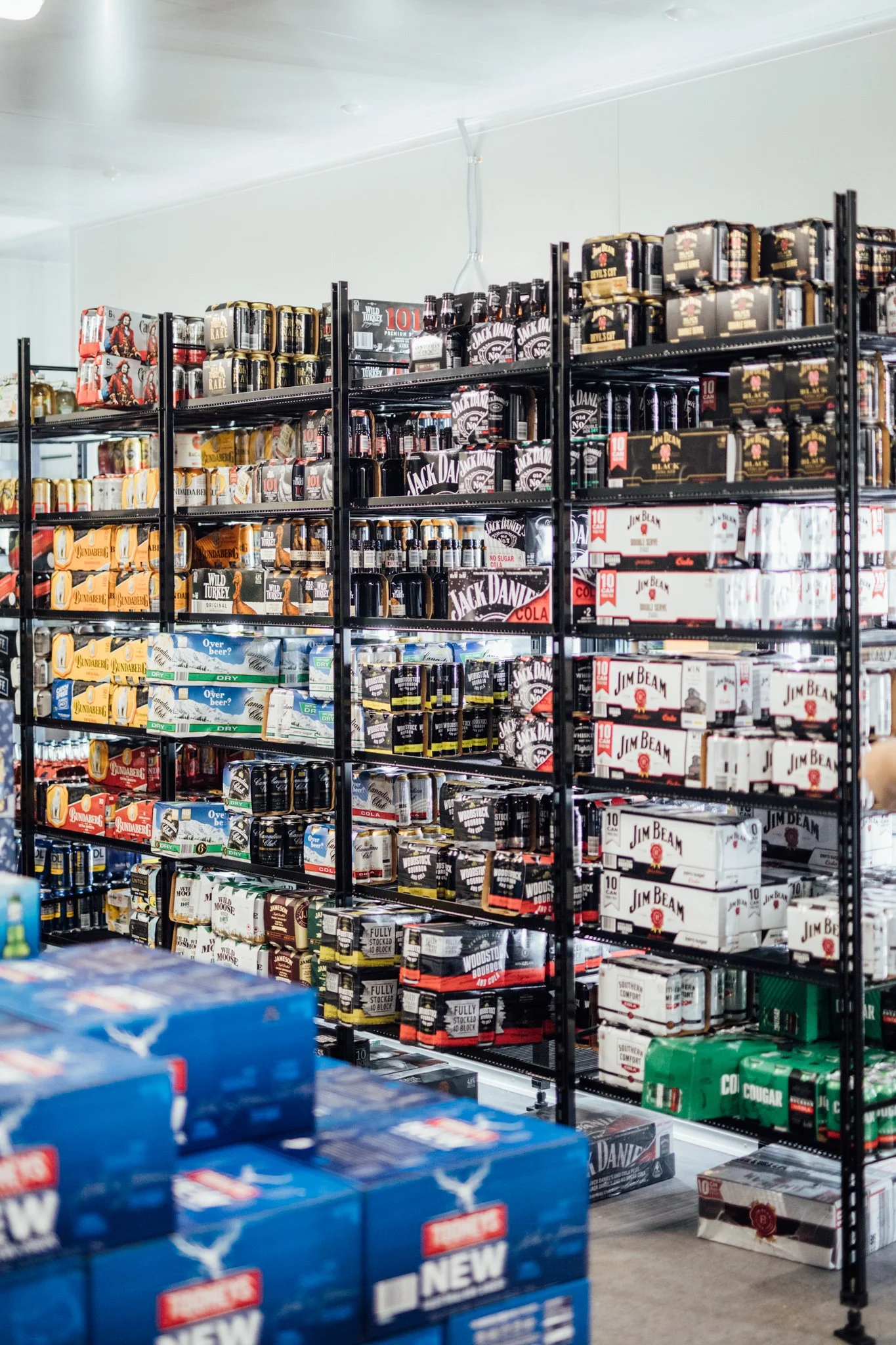 Shelves stocked with various brands of beer and alcohol in a store.