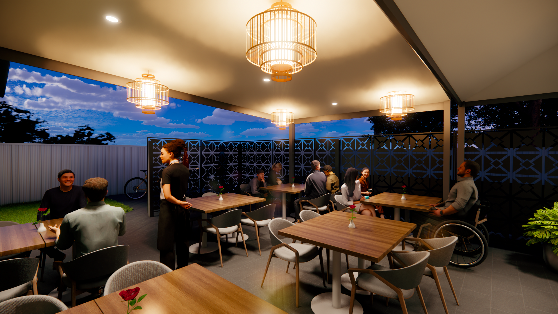 An outdoor patio of a restaurant during early evening, with groups of people dining and chatting. The space is decorated with hanging lights and small vases with red roses on tables, enclosed by a black patterned fence, and a bicycle leans against th