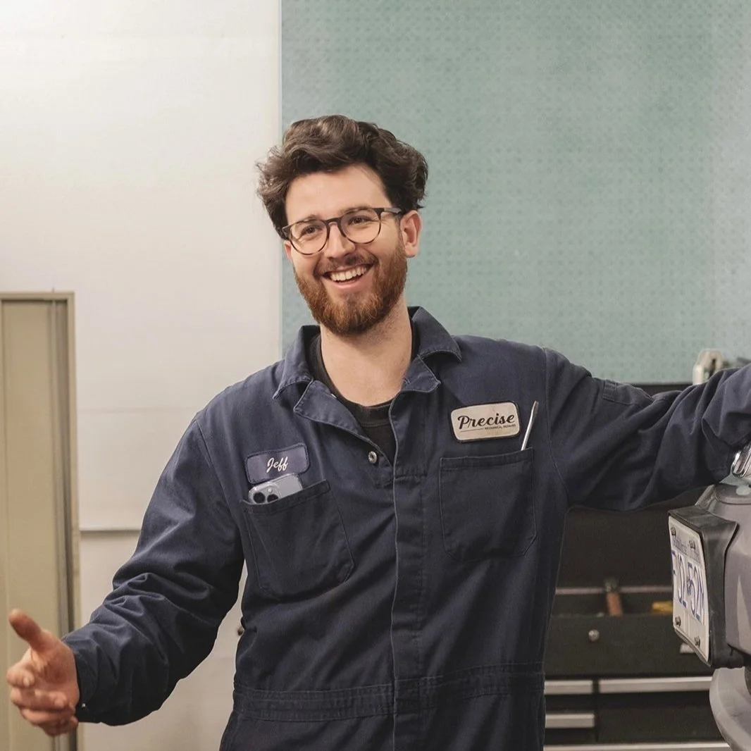 CEO, 'Jeff', and company patch 'Precise' standing in a workshop.