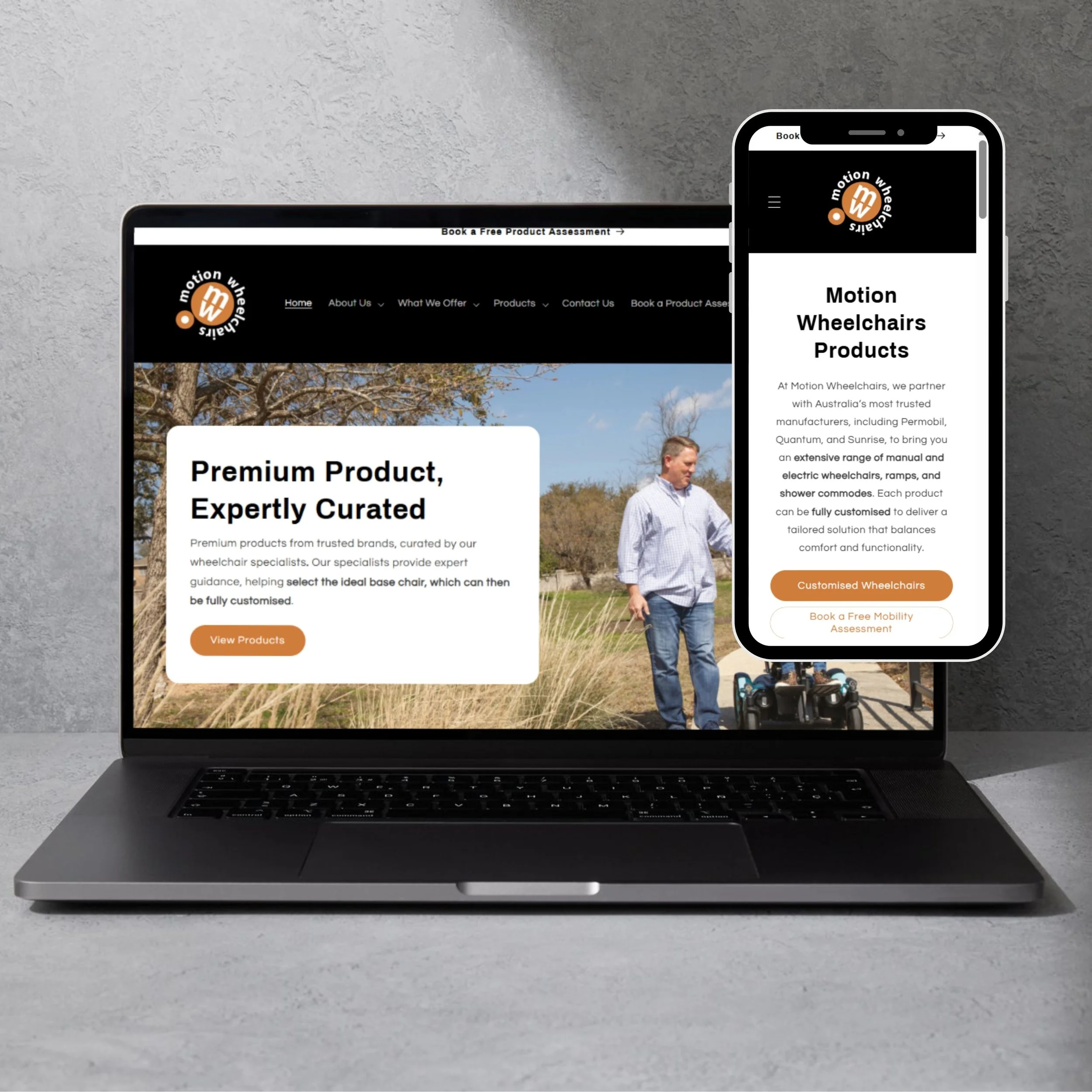 Close-up of a person in a wheelchair wearing a wristband, adjusting a black electronic device attached to their leg, outdoors with trees and cars in the background.