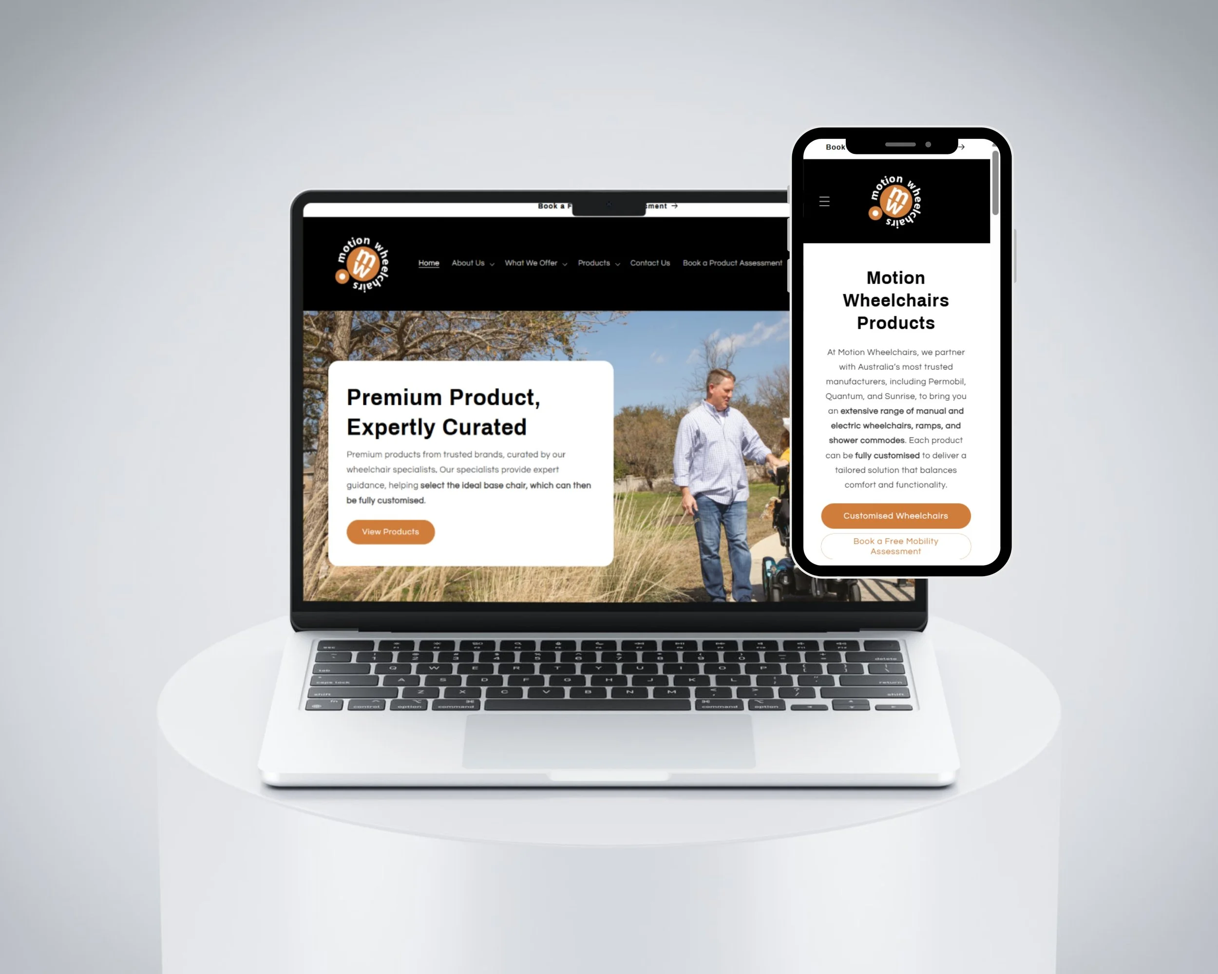 A MacBook laptop and a smartphone displaying a website for Motion Wheelchairs Products. The laptop screen shows an outdoor scene with a man in a wheelchair, while the mobile screen shows branded content about he custom wheelchairs from the company.