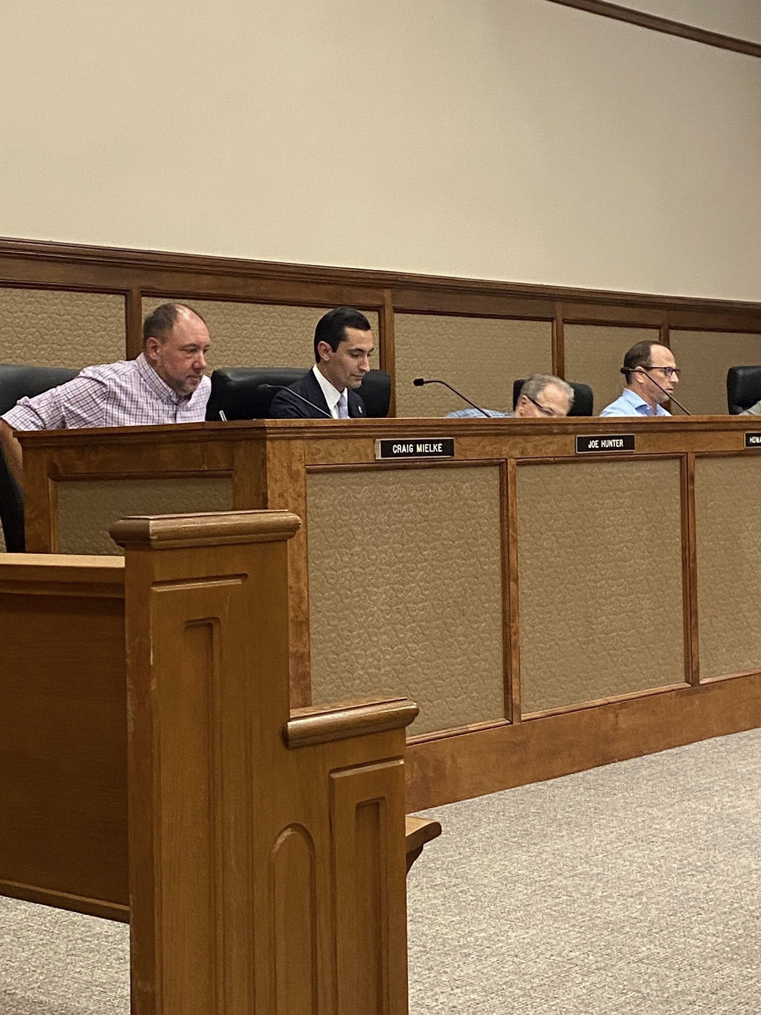 Judges sitting at a panel in a courtroom, with wooden fixtures and nameplates.
