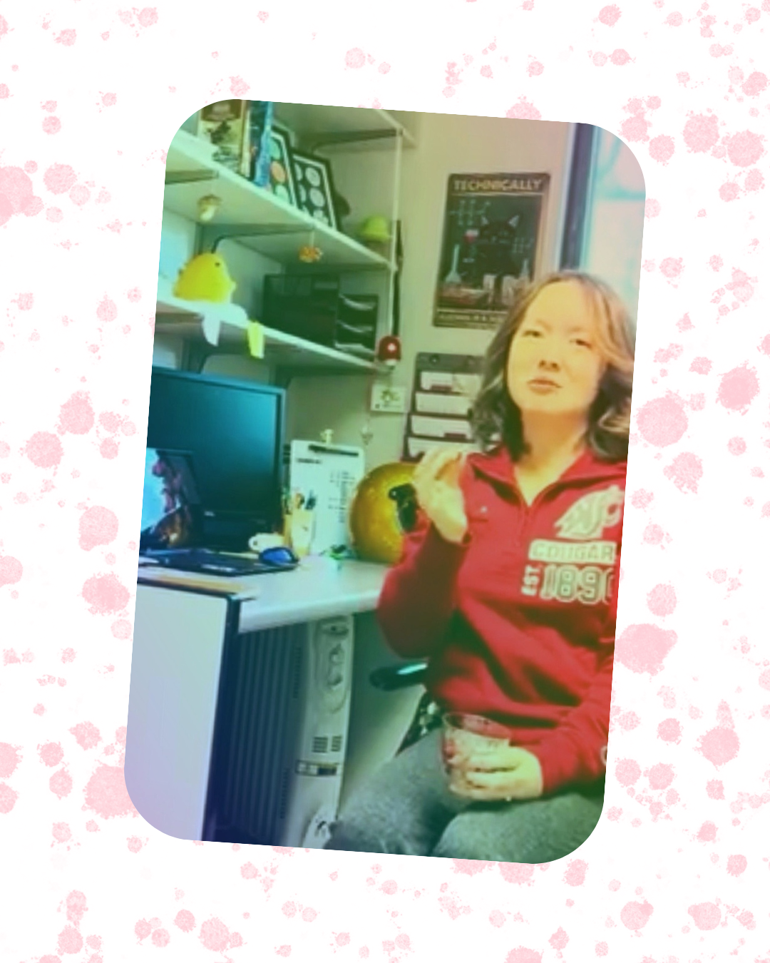 Ahhria Kirkendall, The Cranberry Doctor, working in her research office with a computer and scientific materials, holding a cranberry sample and a cup of cranberries.