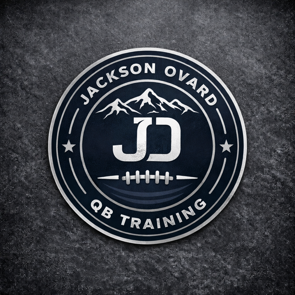A circular logo with the text 'Jackson Ovard QB Training' around the perimeter, a mountain range at the top, and a football with a lacing pattern in the center.