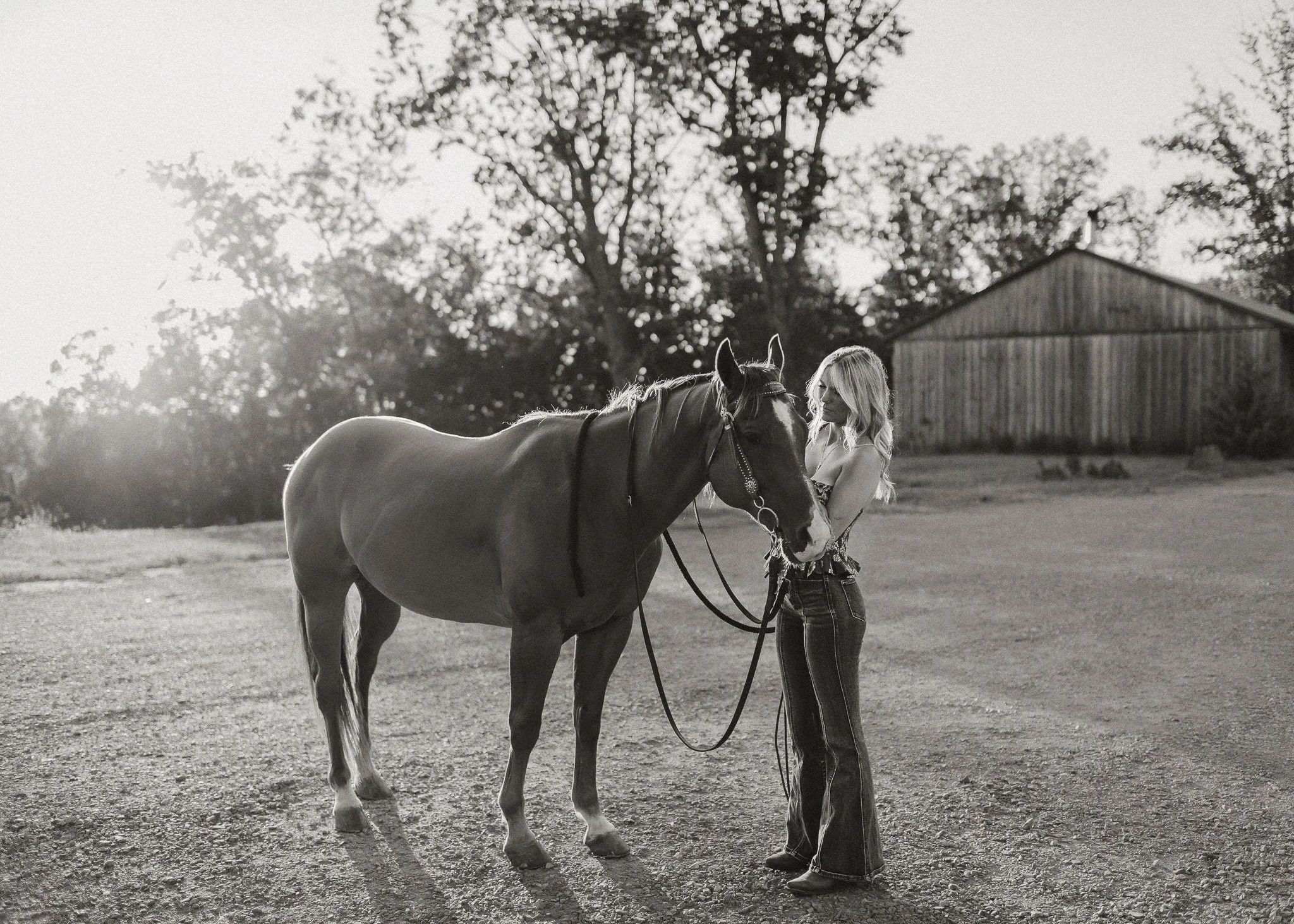 Black and white photo of high school girl with her house outdoors during senior session in Georgia by Raquel Zane Photography