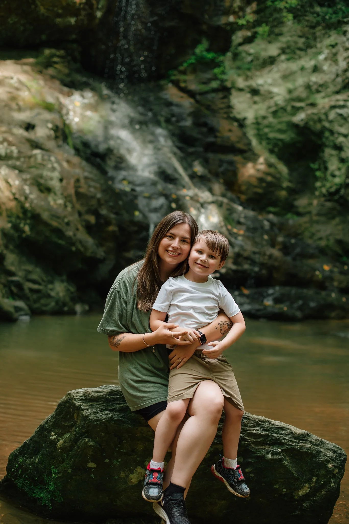Mom and son portrait in front of waterfall at High Shoal Falls in Dallas, Georgia by Raquel Zane Photography
