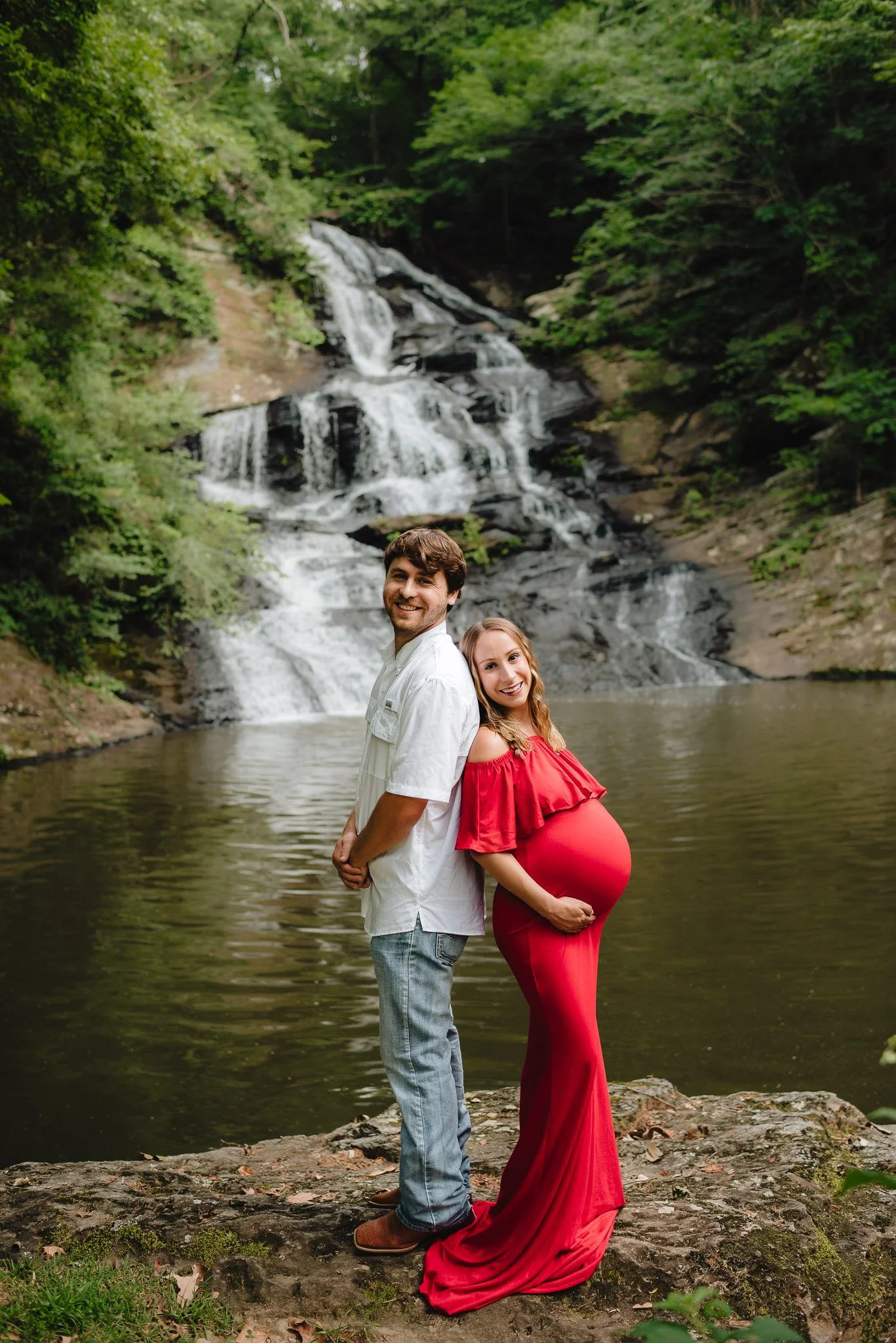 Couple standing back to back in front of waterfall in North Georgia by Raquel Zane Photography