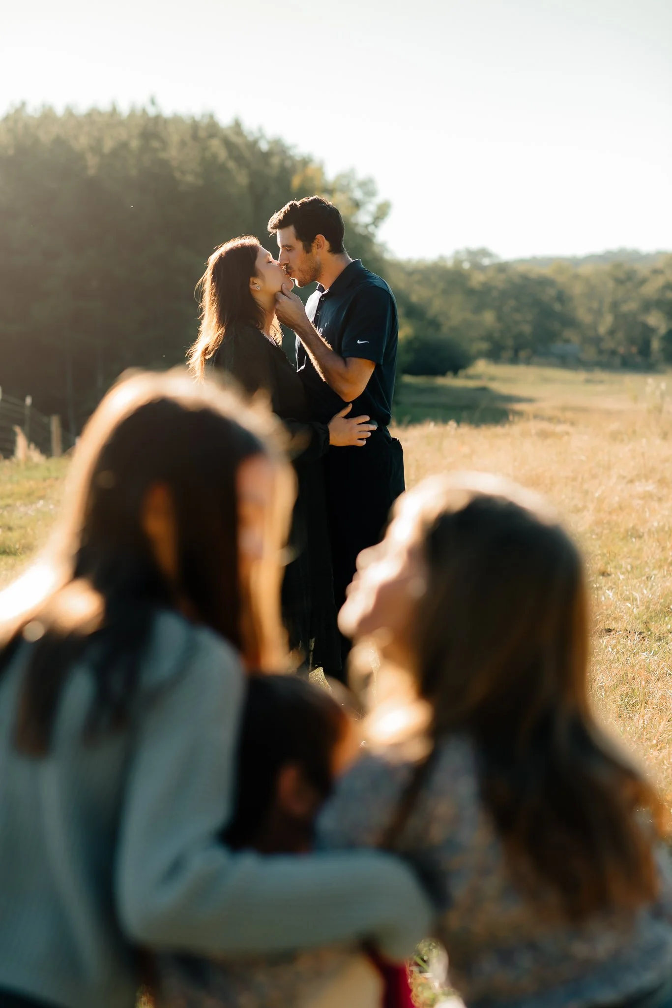 Mom and Dad laughing in background with kids in foreground family session outdoors by Raquel Zane Photography