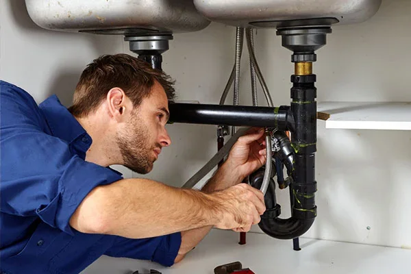 Plumber performing maintenance and repair services for a commercial facility