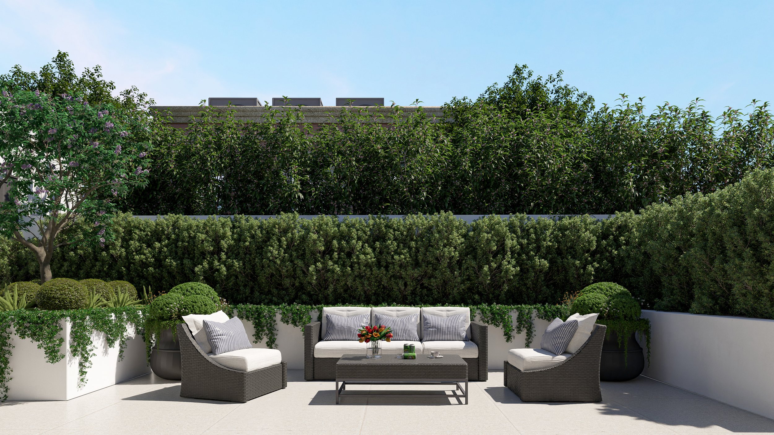 Modern outdoor patio with white seating area and lush green hedges and trees background